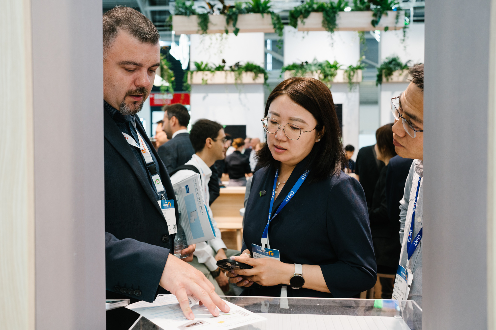 Trade-fair visitors discussing project details in a busy exhibition hall