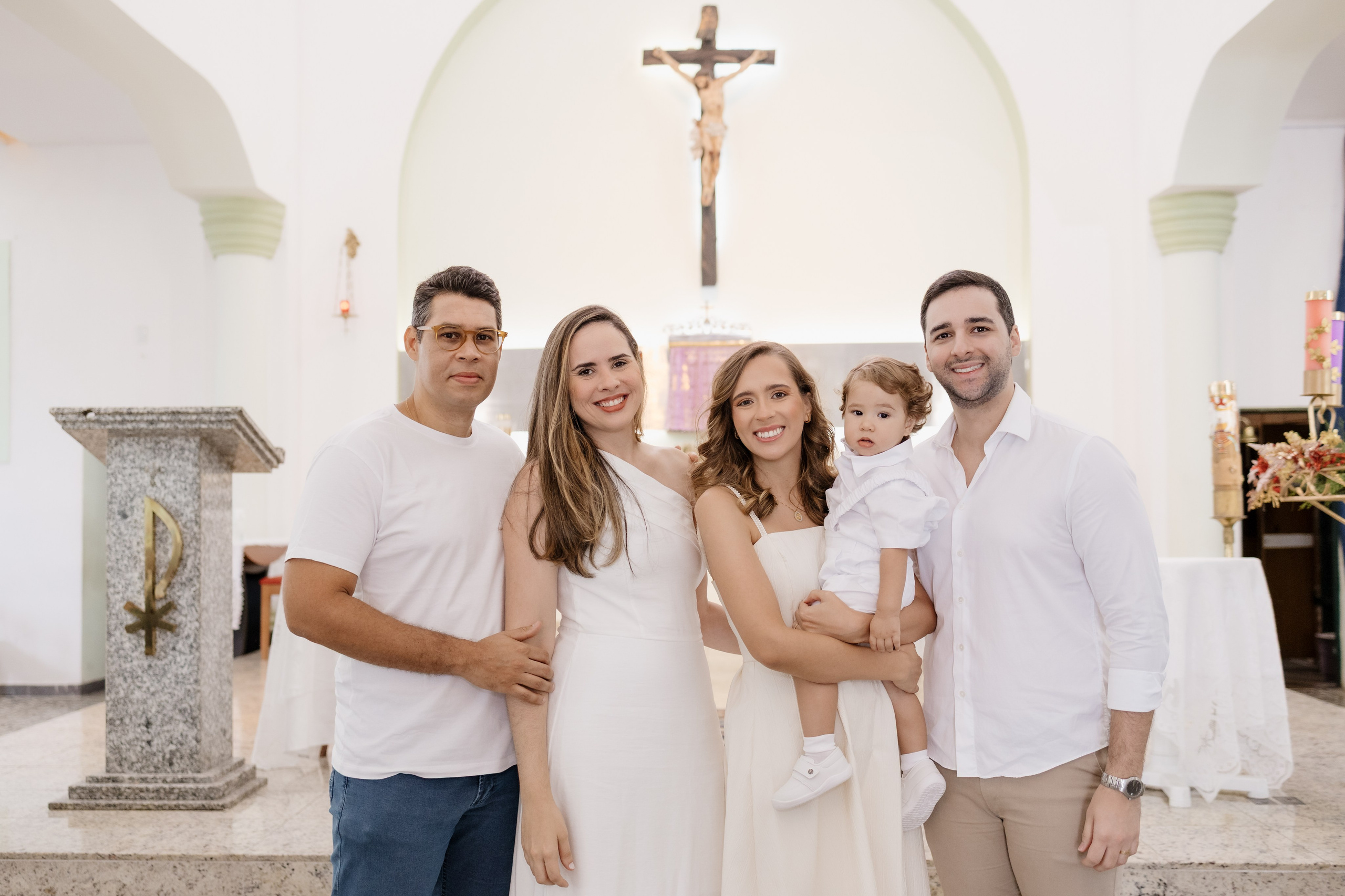 Foto dos pais e padrinhos em frente ao altar no batizado