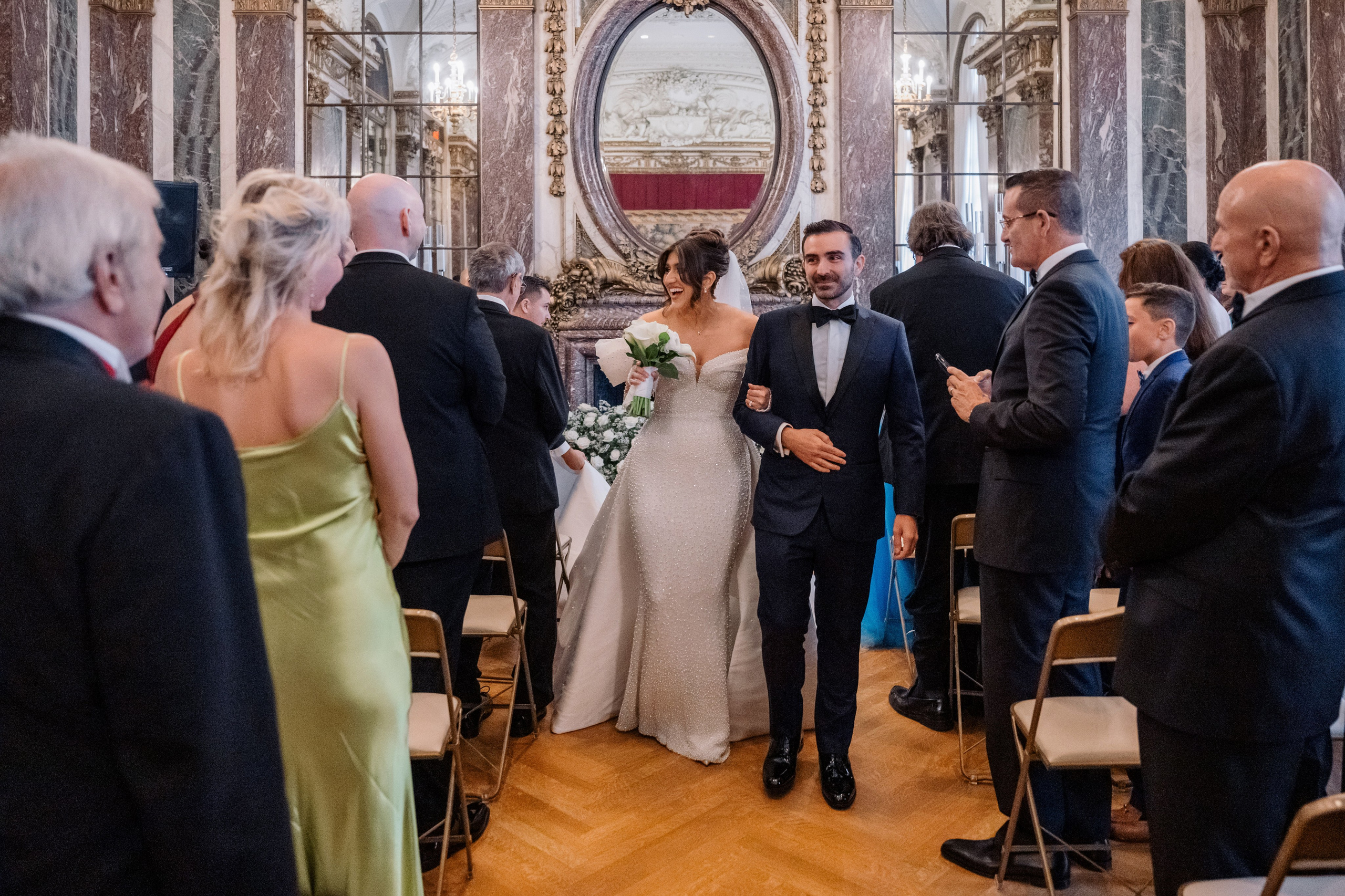 a bride and groom walking down the aisle