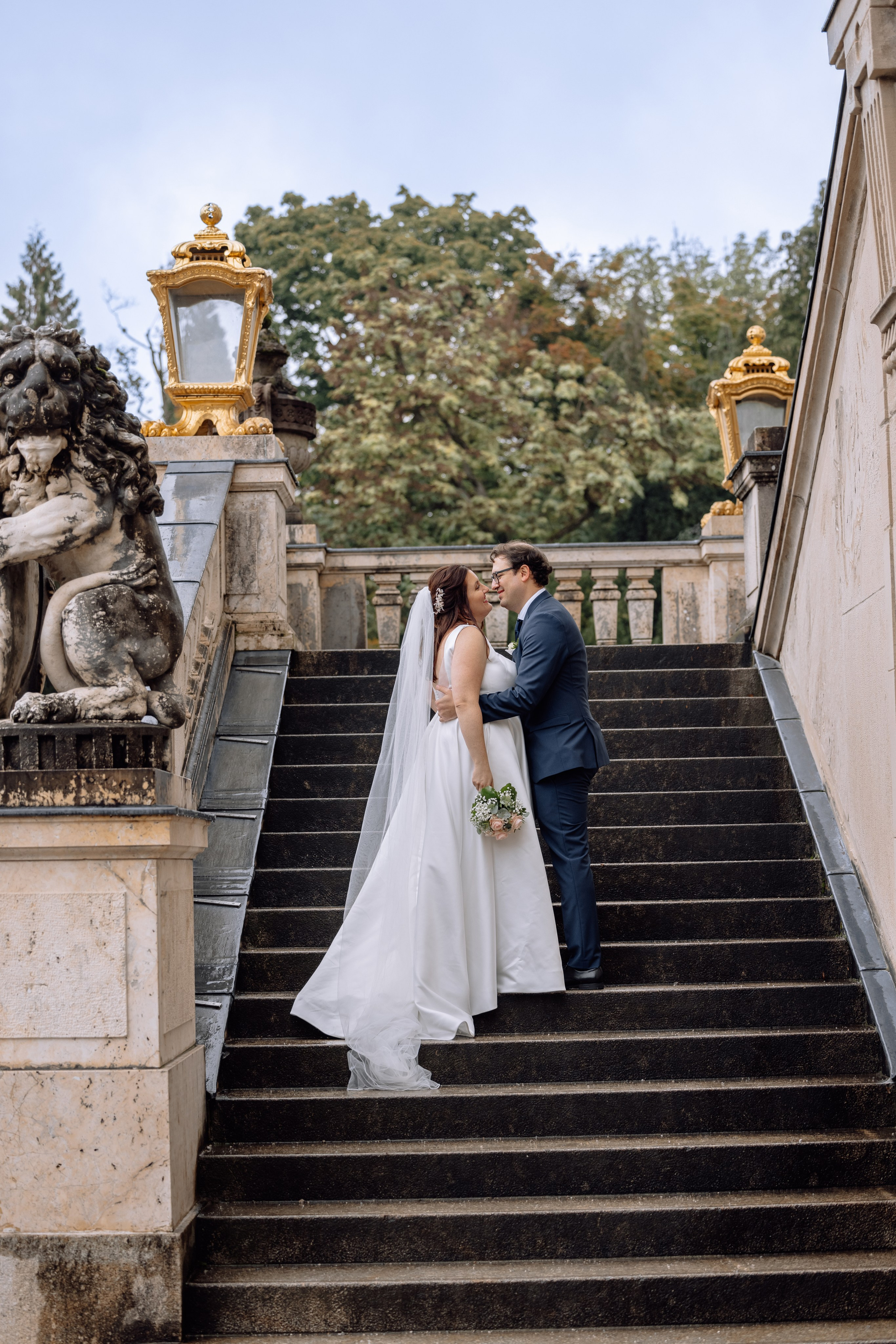 Bräutigam küsst die Braut auf der Treppe vor dem Schloss Nymphenburg