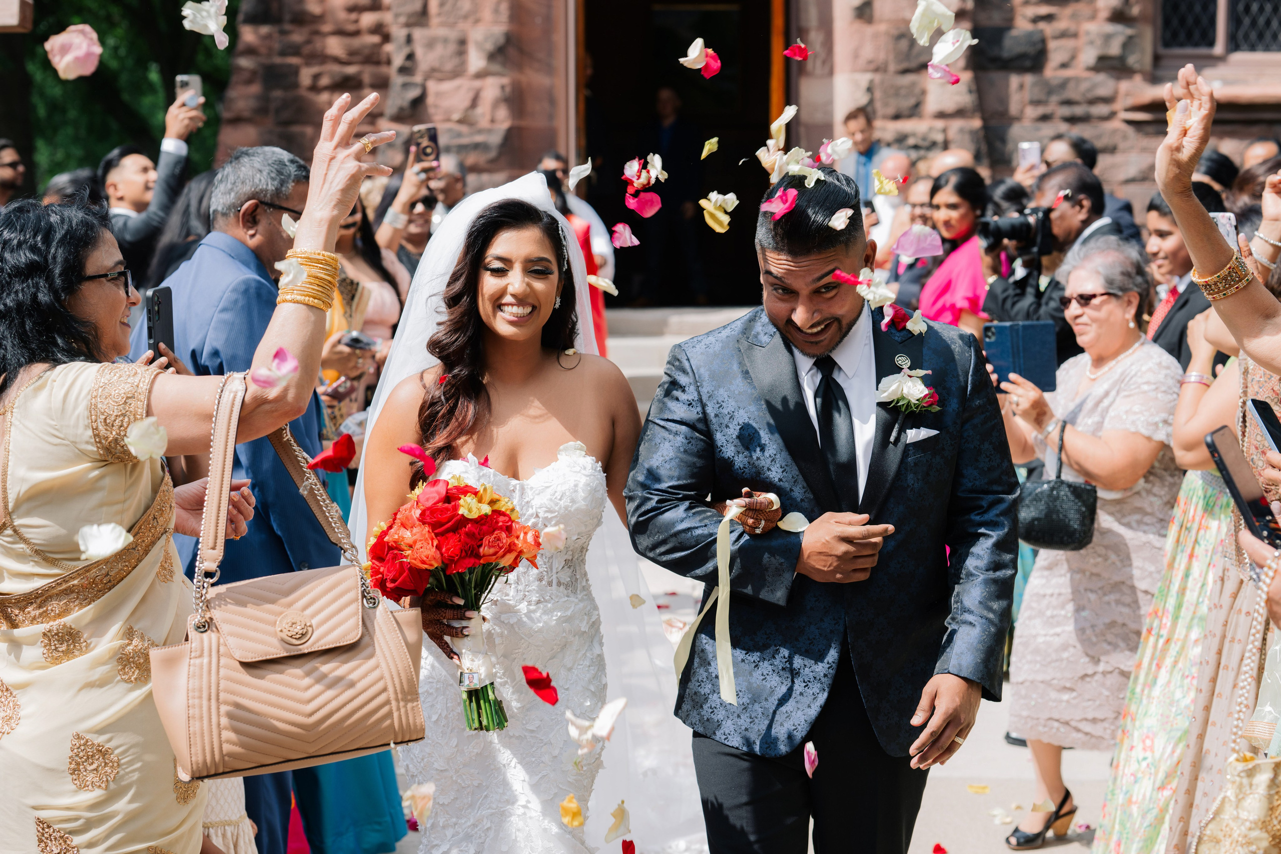 a bride and groom walking through a crowd of people