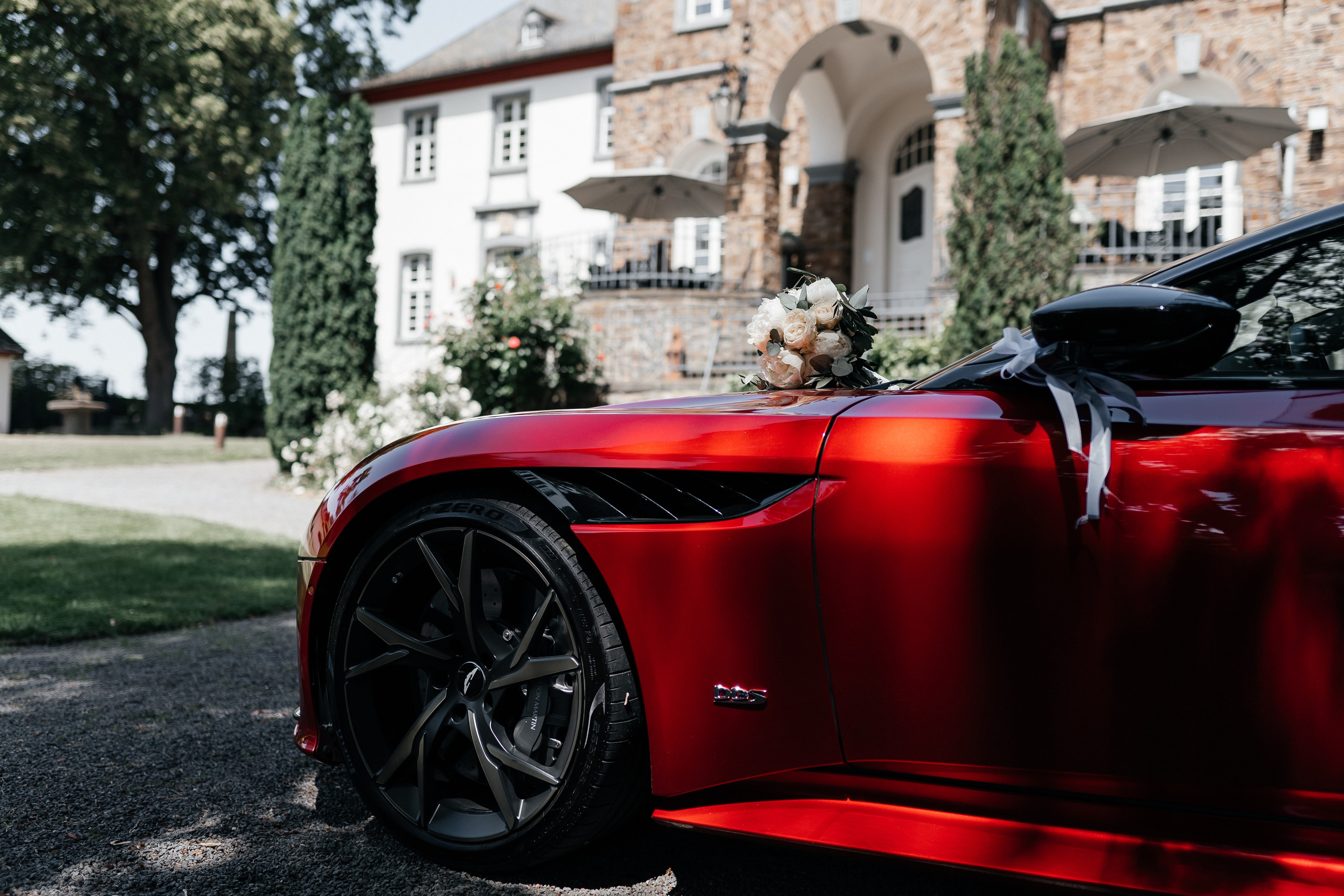 Eleganter Aston Martin als Hochzeitsauto vor einer romantischen Kulisse