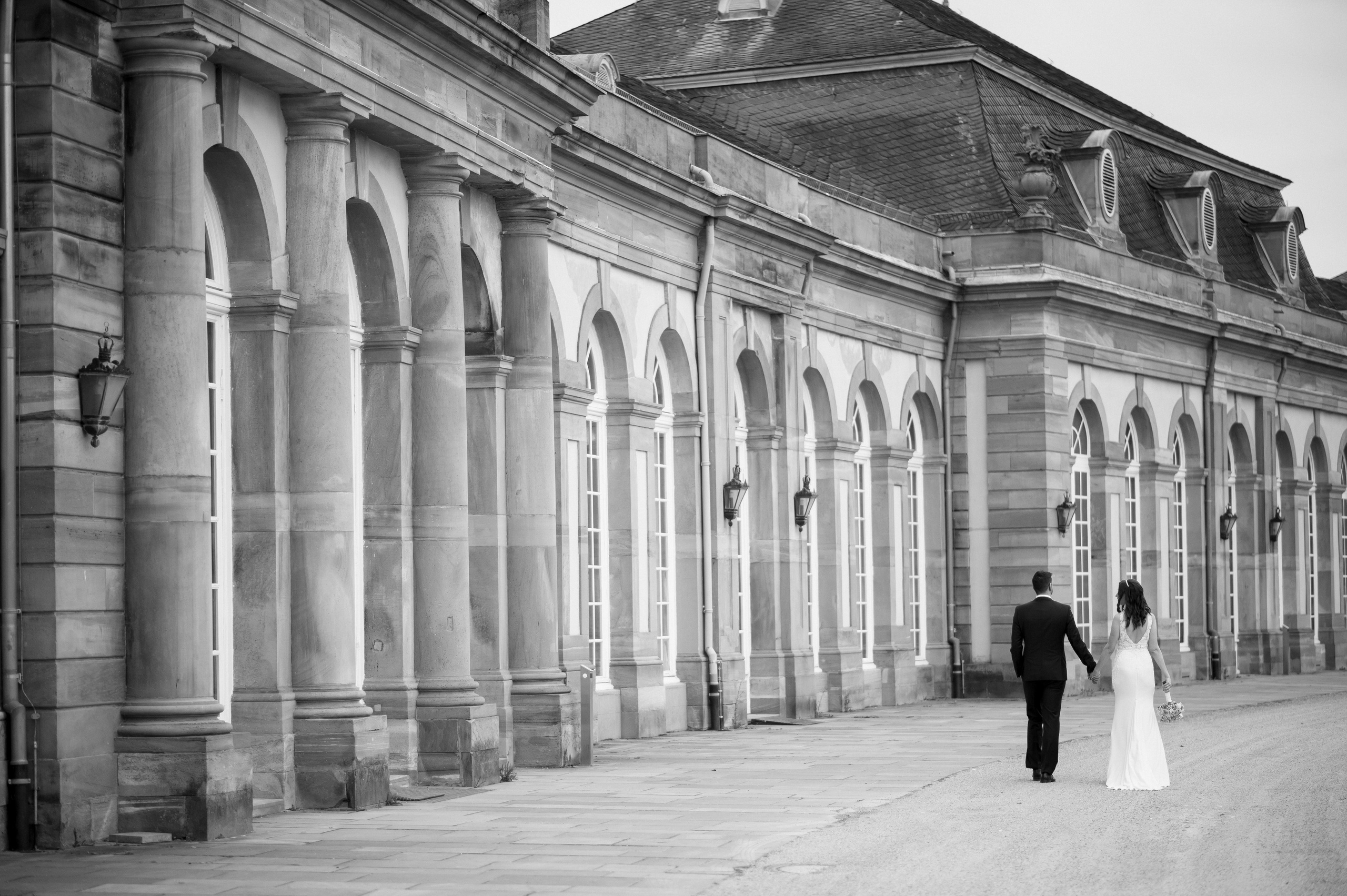 Brautpaar vor den Arkaden von Schloss Schwetzingen in Schwarzweiß