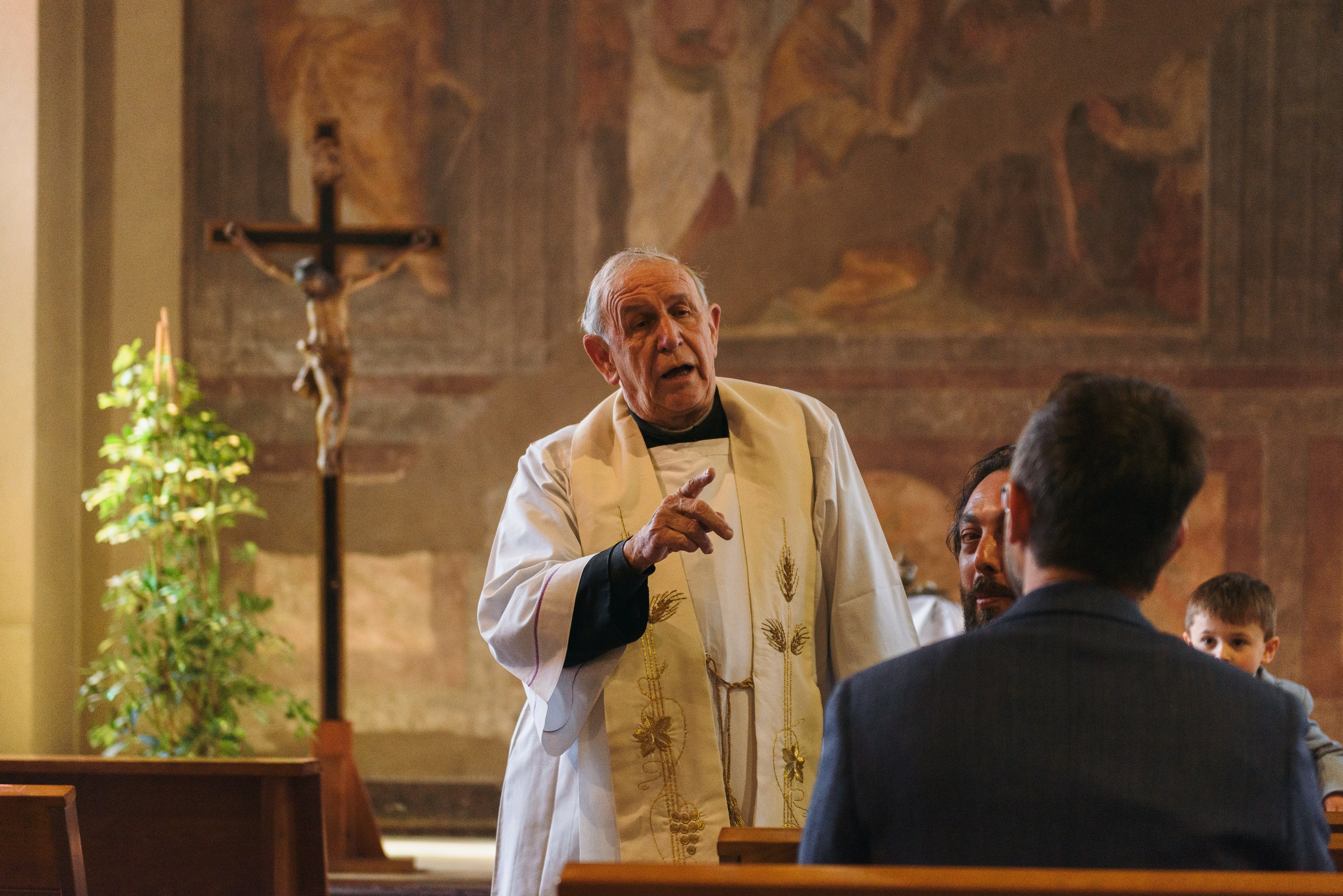 Photographer priest in church in Milan. Baptism Photographer