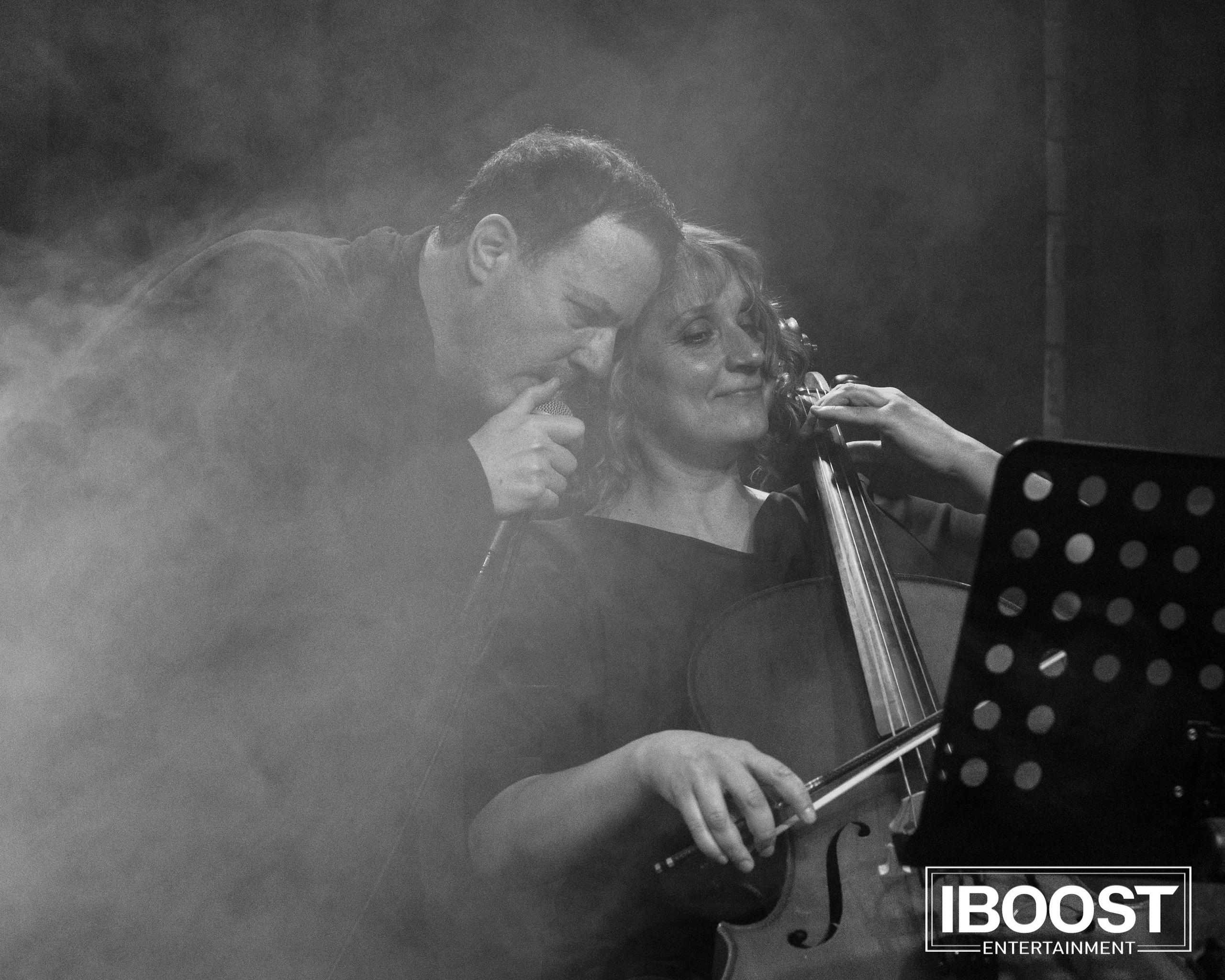 Black-and-white photo of the lead vocalist of Animal JazZ performing in smoke beside a music stand.