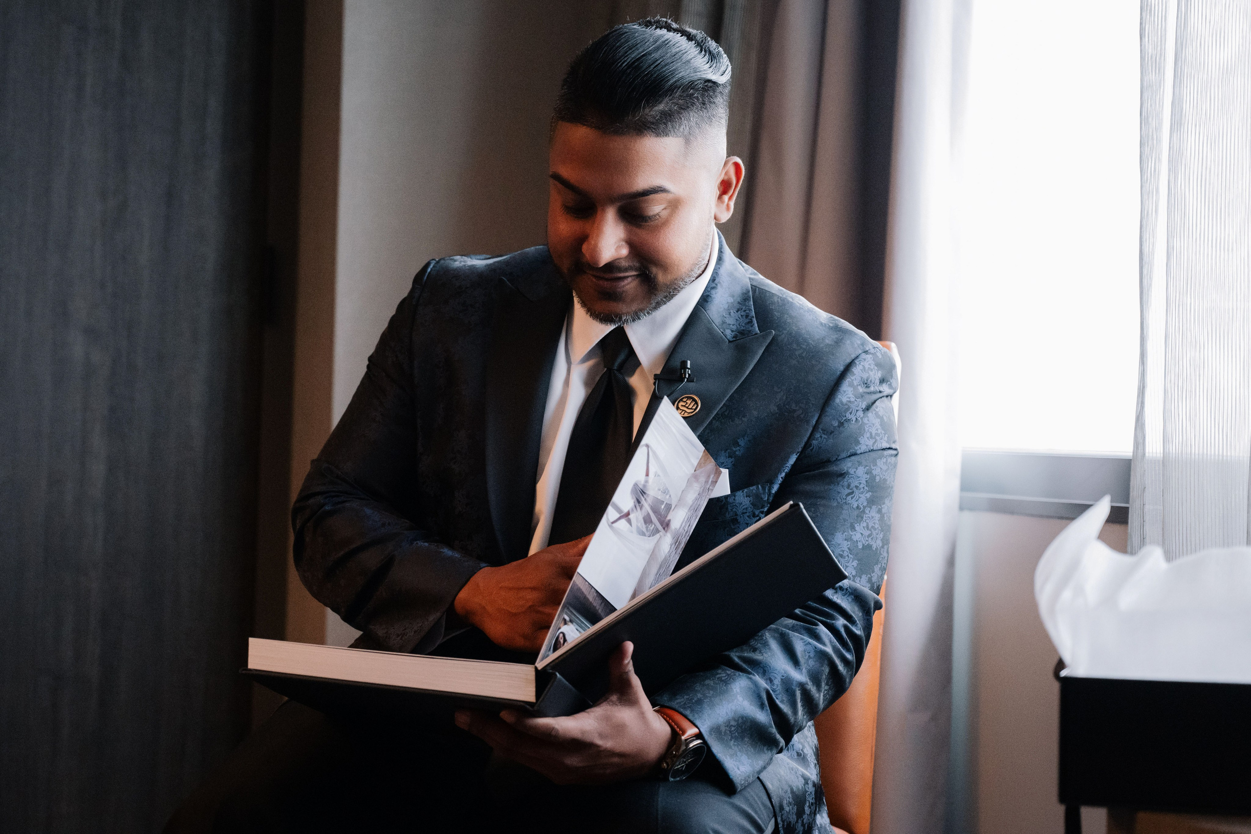 a man in a suit and tie holding a book