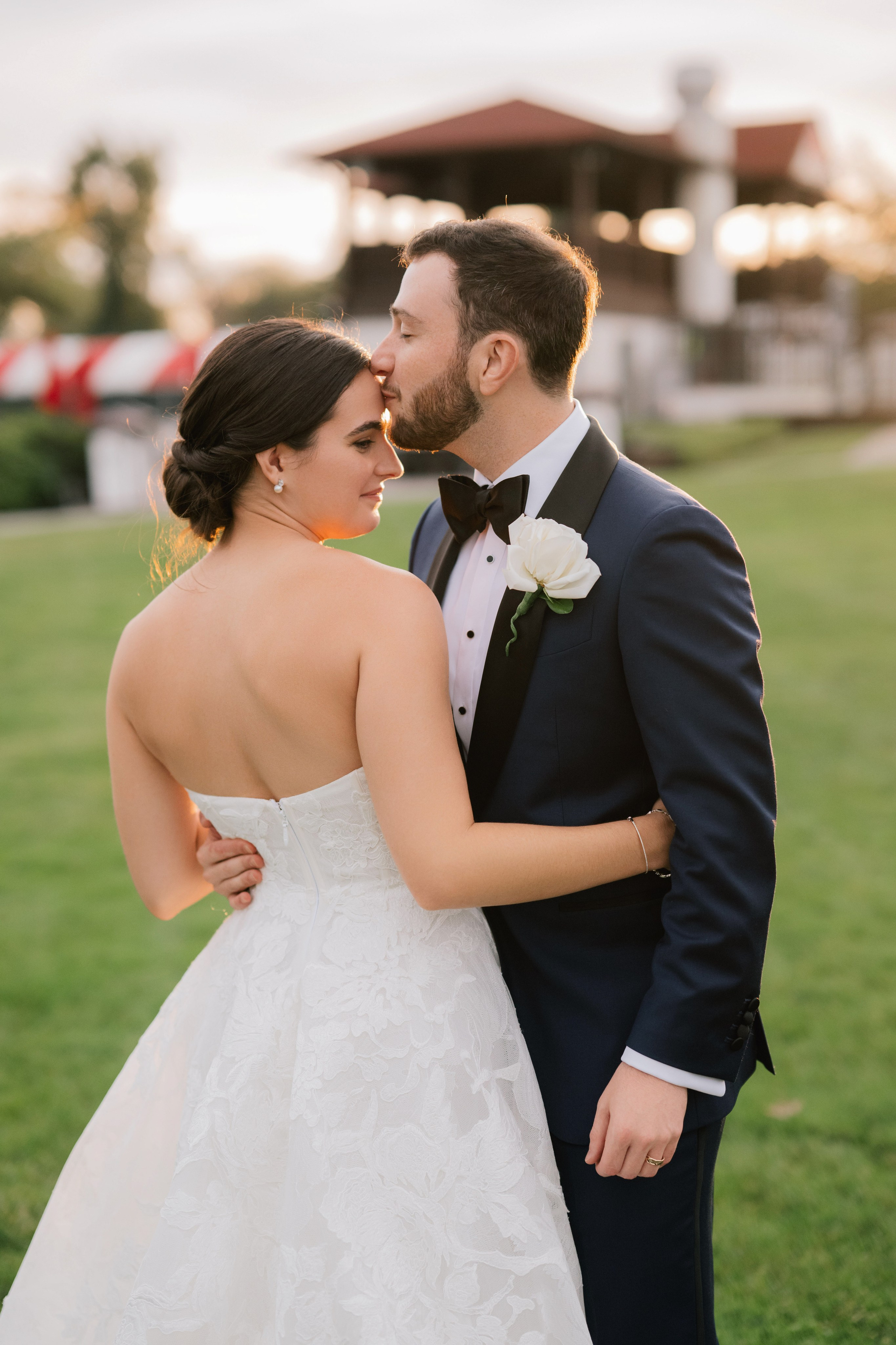 a bride and groom pose for a photo in the grass