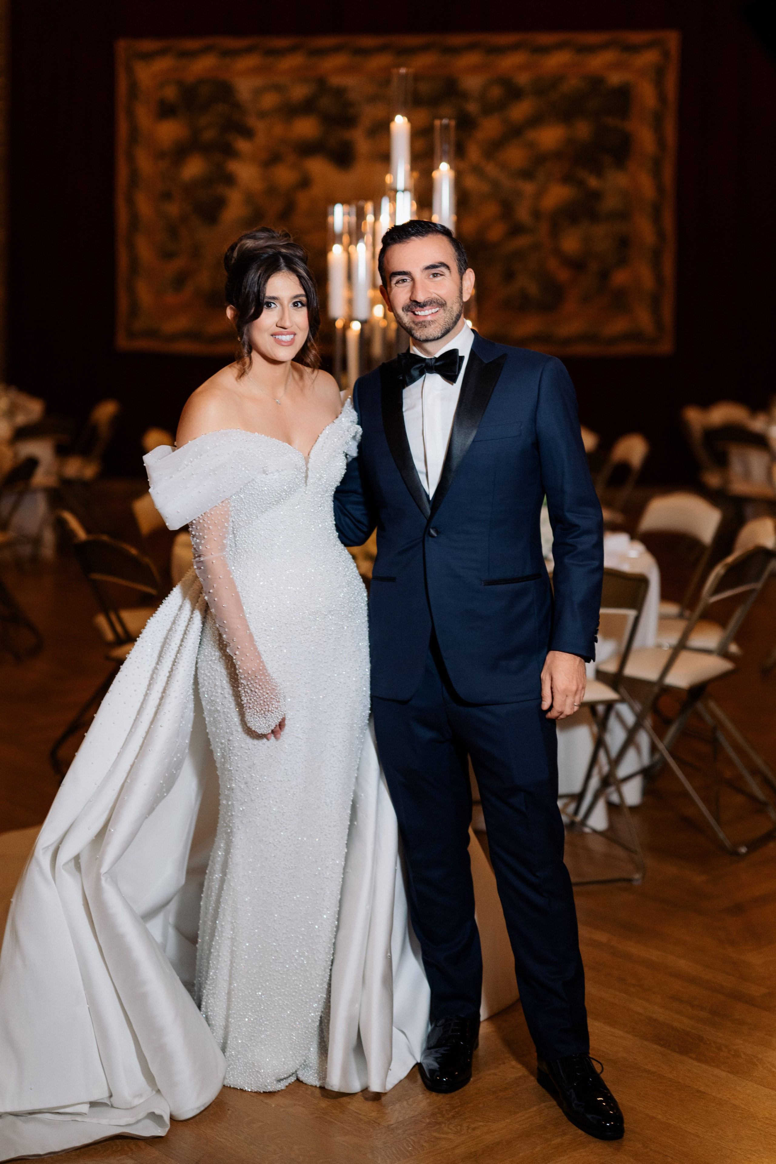 a bride and groom pose for a photo in the ballroom