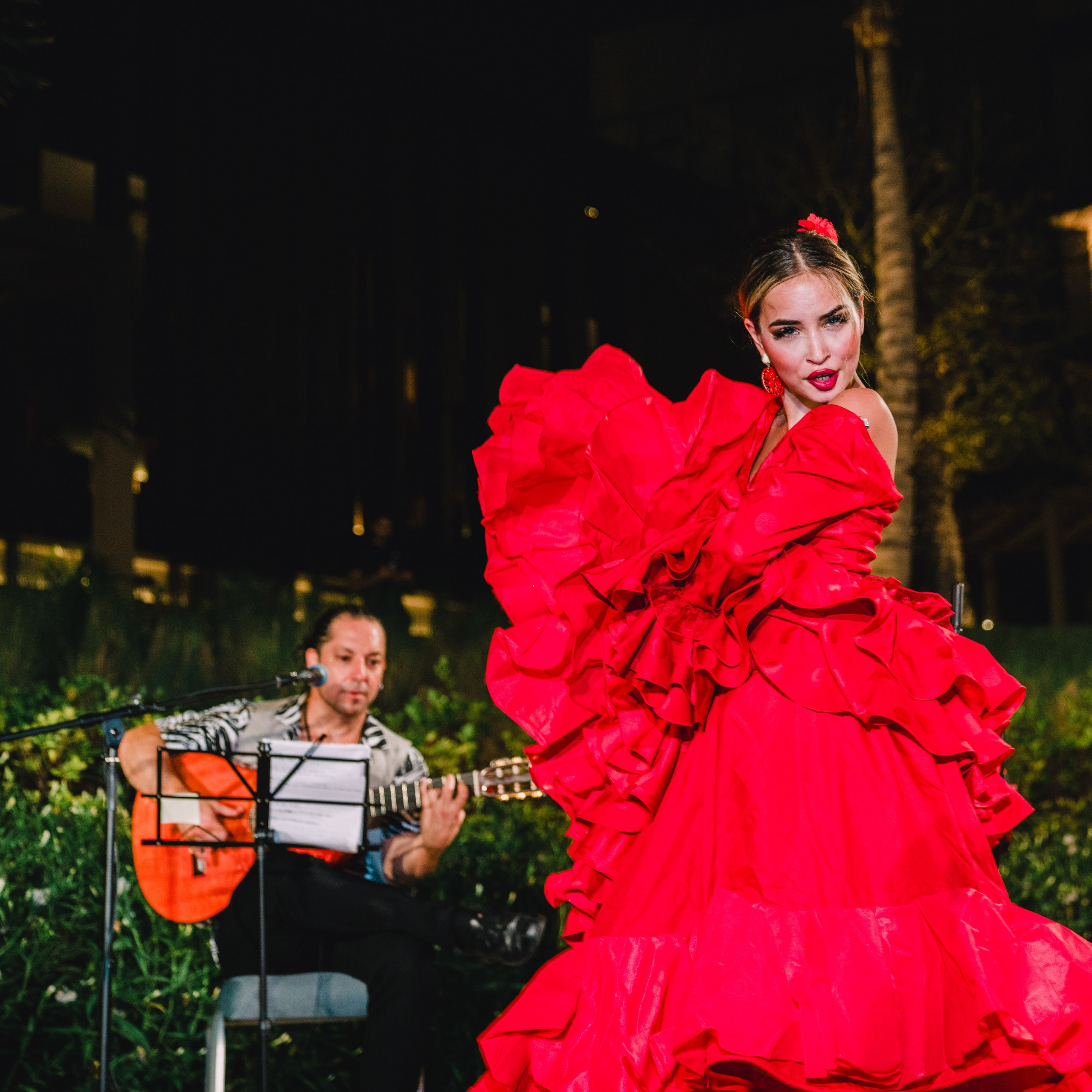 Lady in a red dress is dancing flamenco