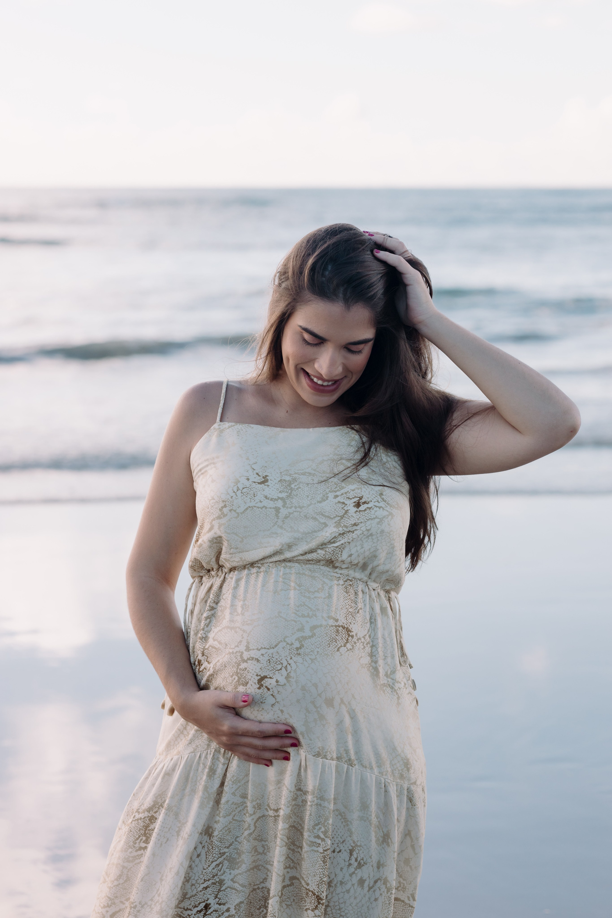 Gestante em ensaio ao amanhecer na praia