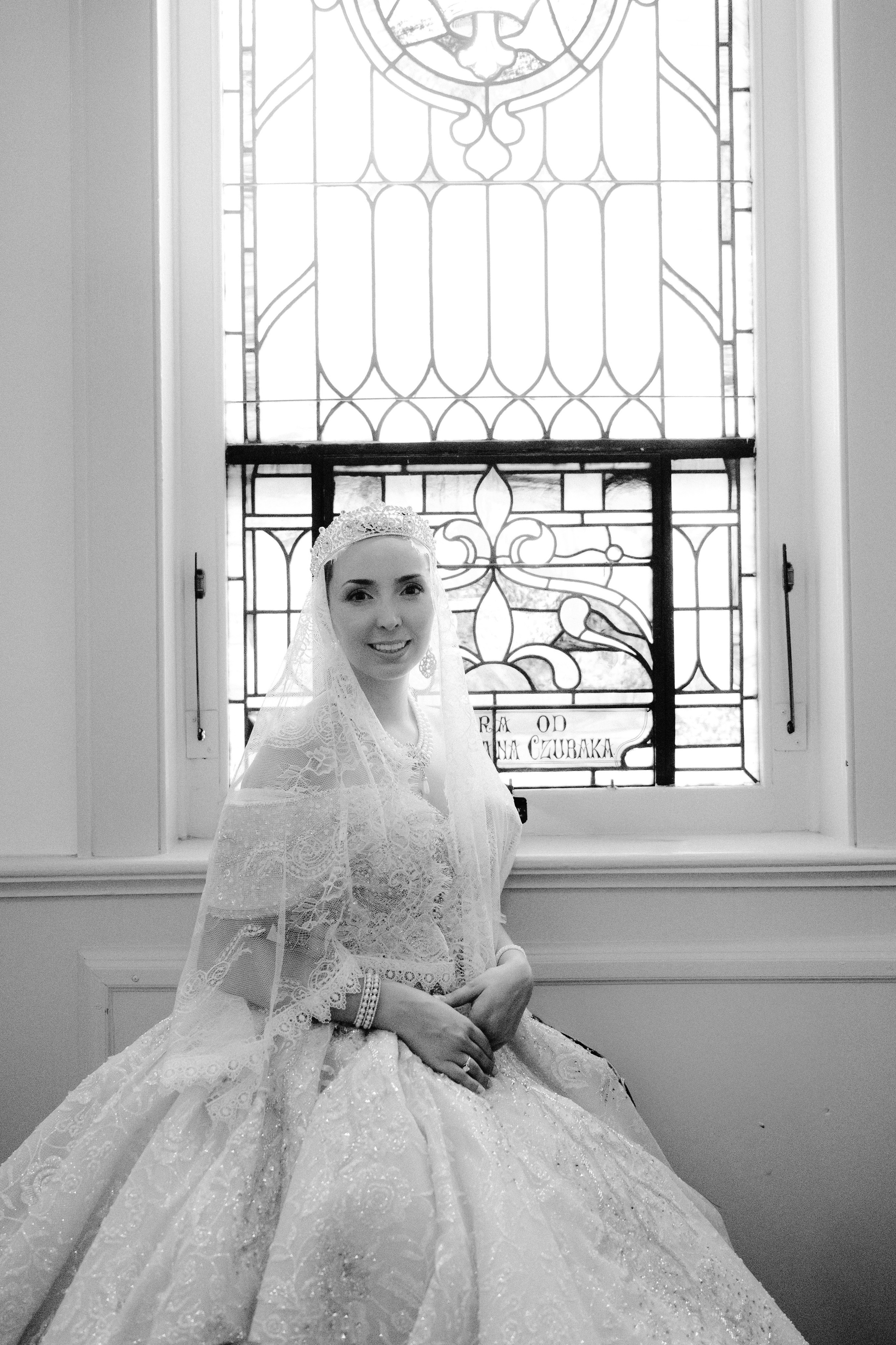 a bride sitting in front of a window