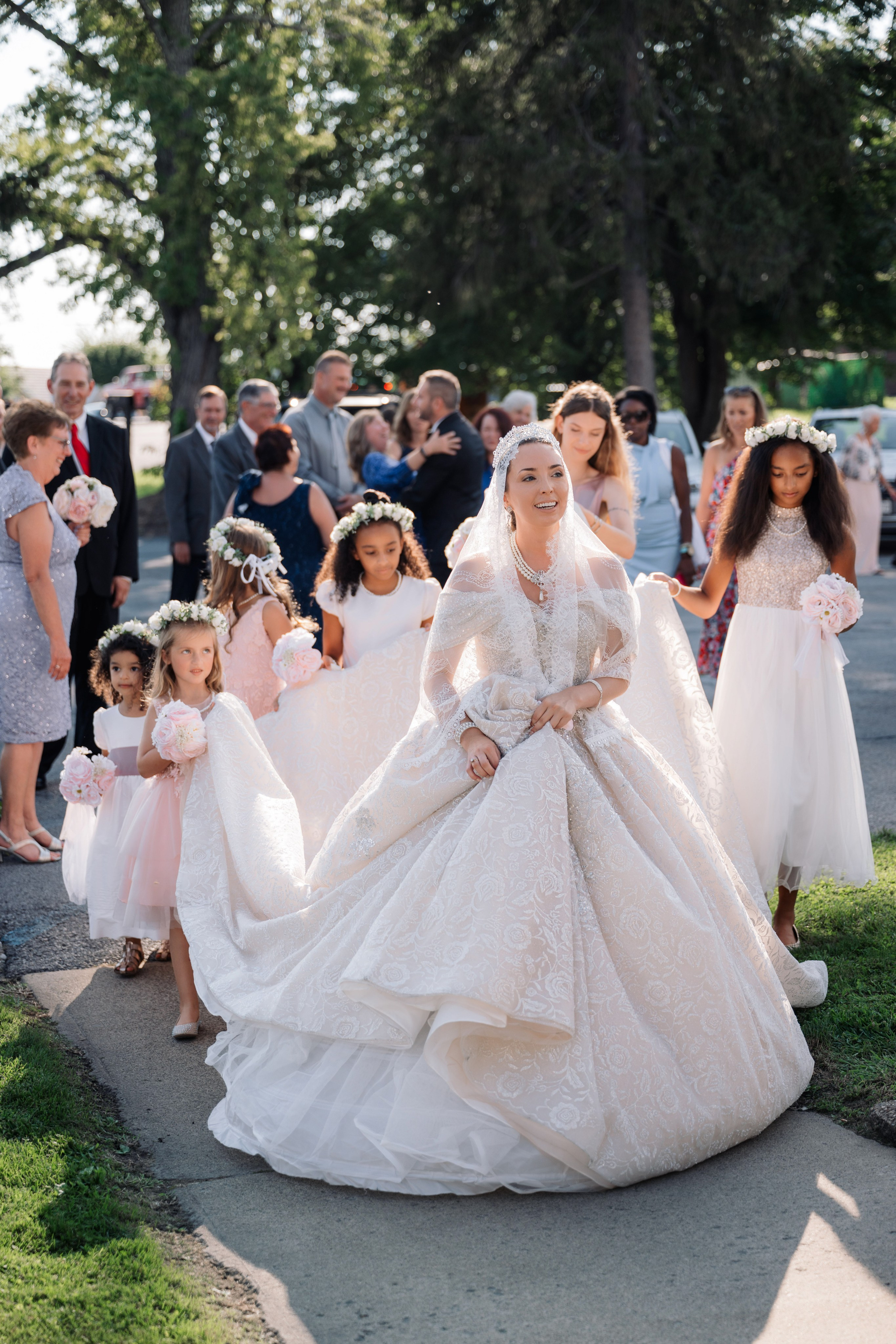 a bride and her flower girls walk down the aisle
