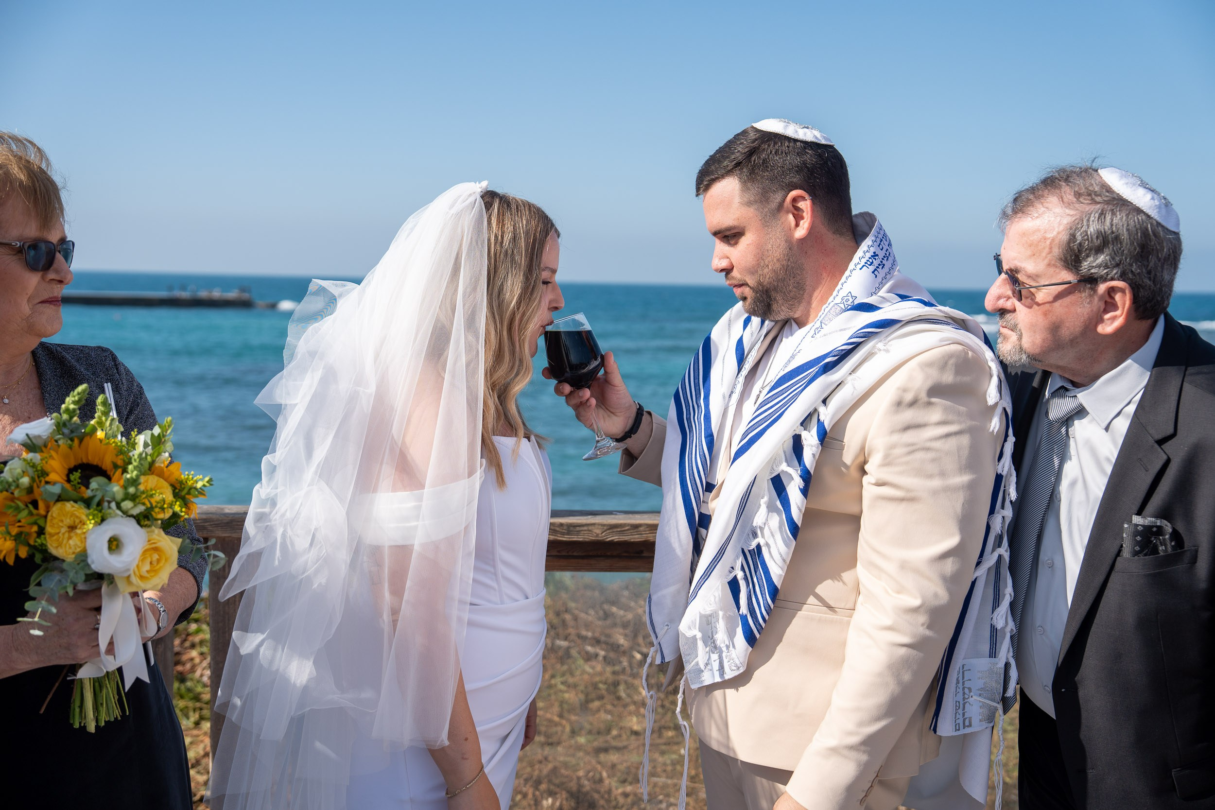 Yael drinks from the ceremonial wine glass beneath the chuppah