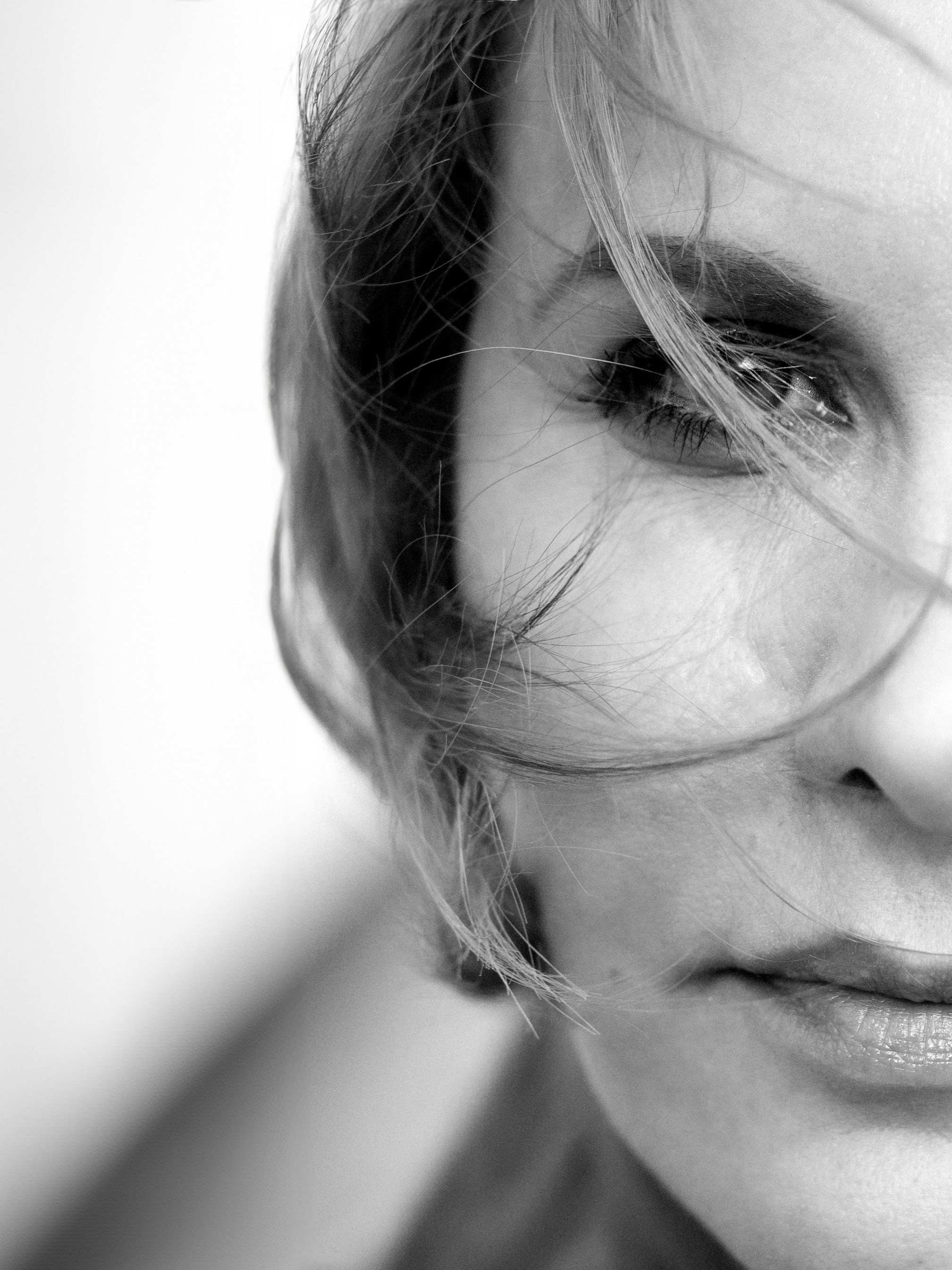 Natürliches Porträt einer Frau draußen mit sanftem Wind in den Haaren