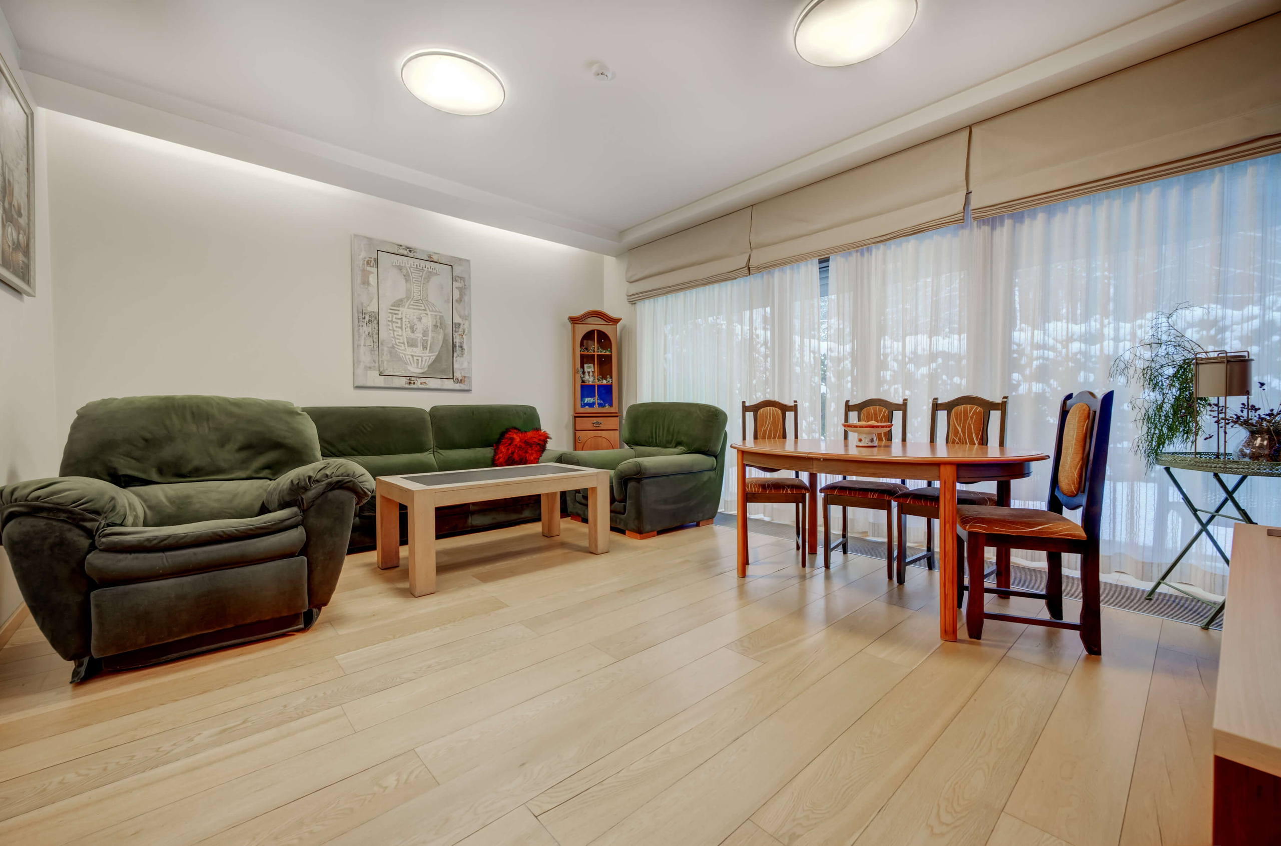 Didelė svetainė su paveikslais ir plačia terasa 4 kambarių dizainerio bute Vilniuje