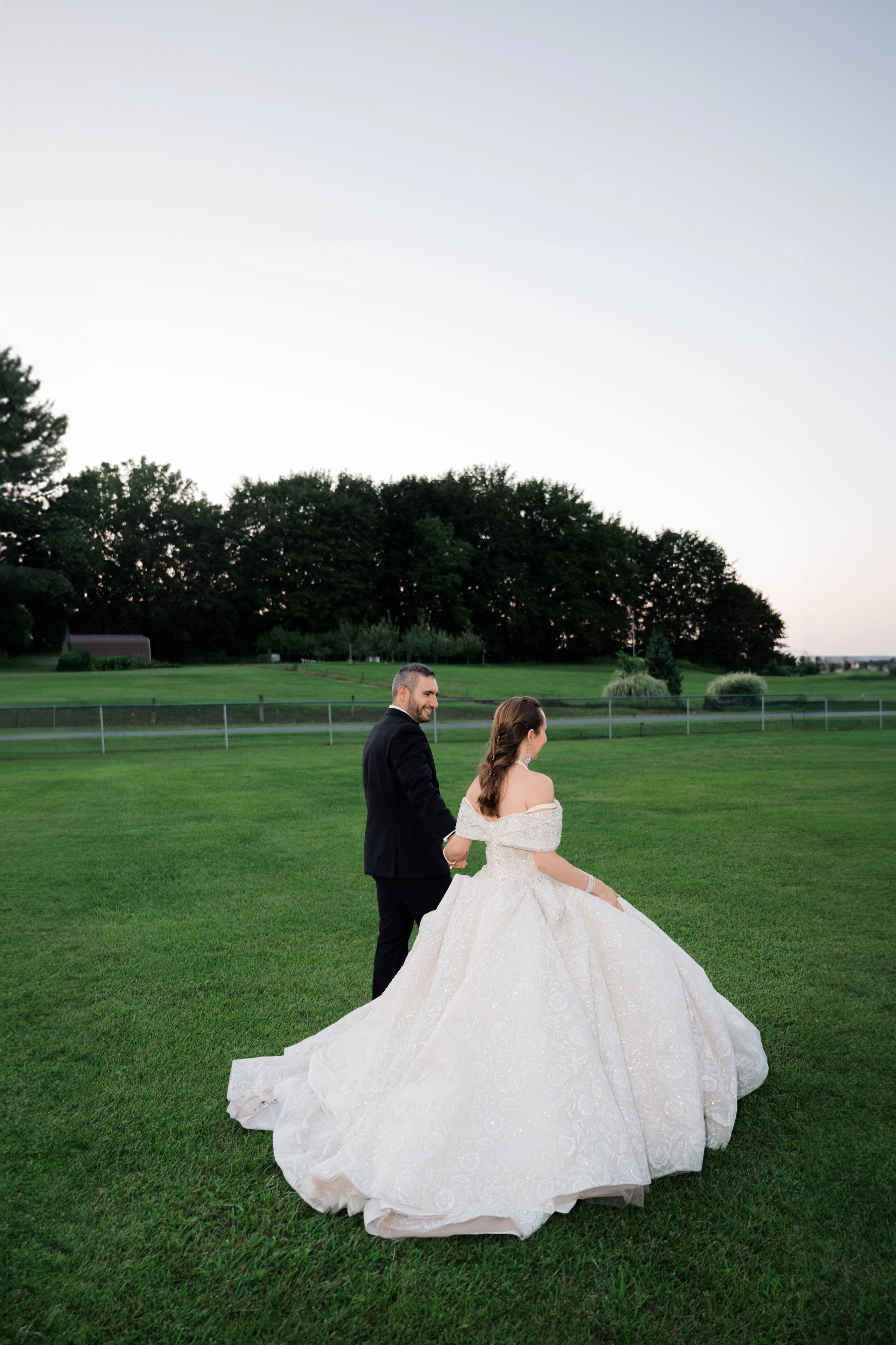 a bride and groom are sitting in the grass