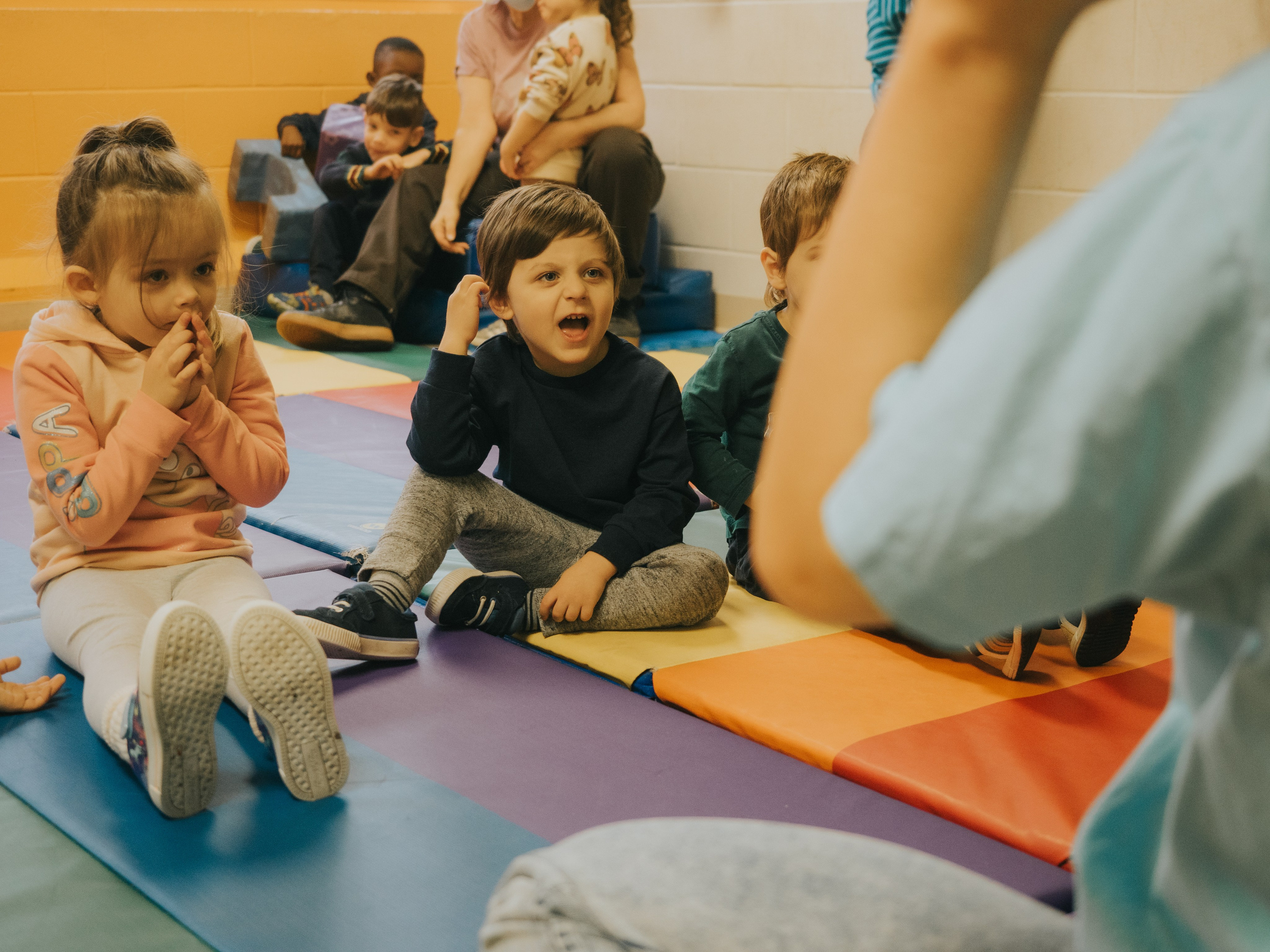 Children in daycare looking towards the dance teacher.