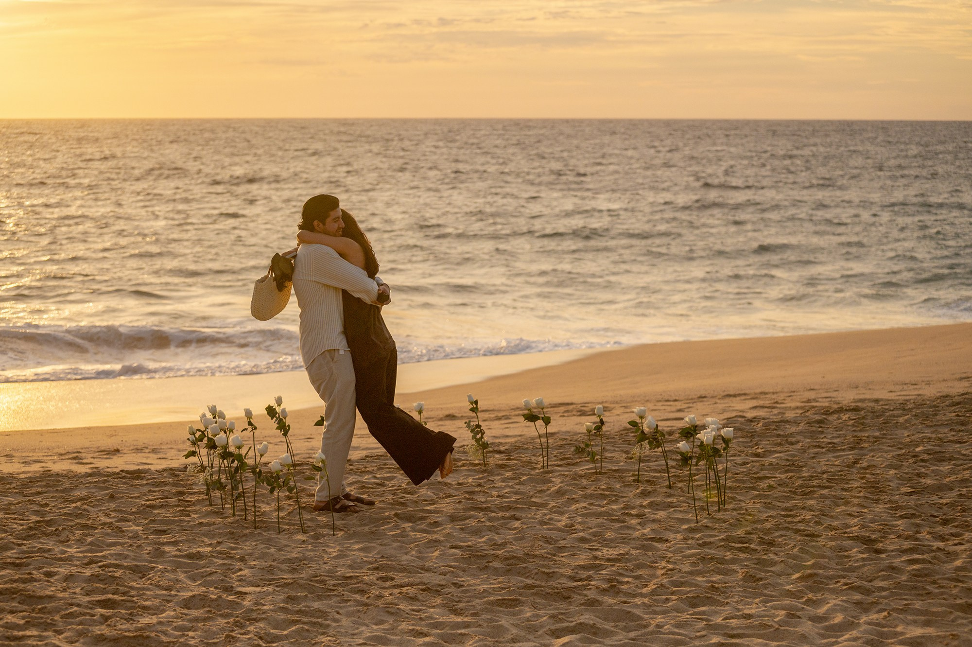 Couple hugging after surprise proposal on the beach in Baja California Sur Mexico