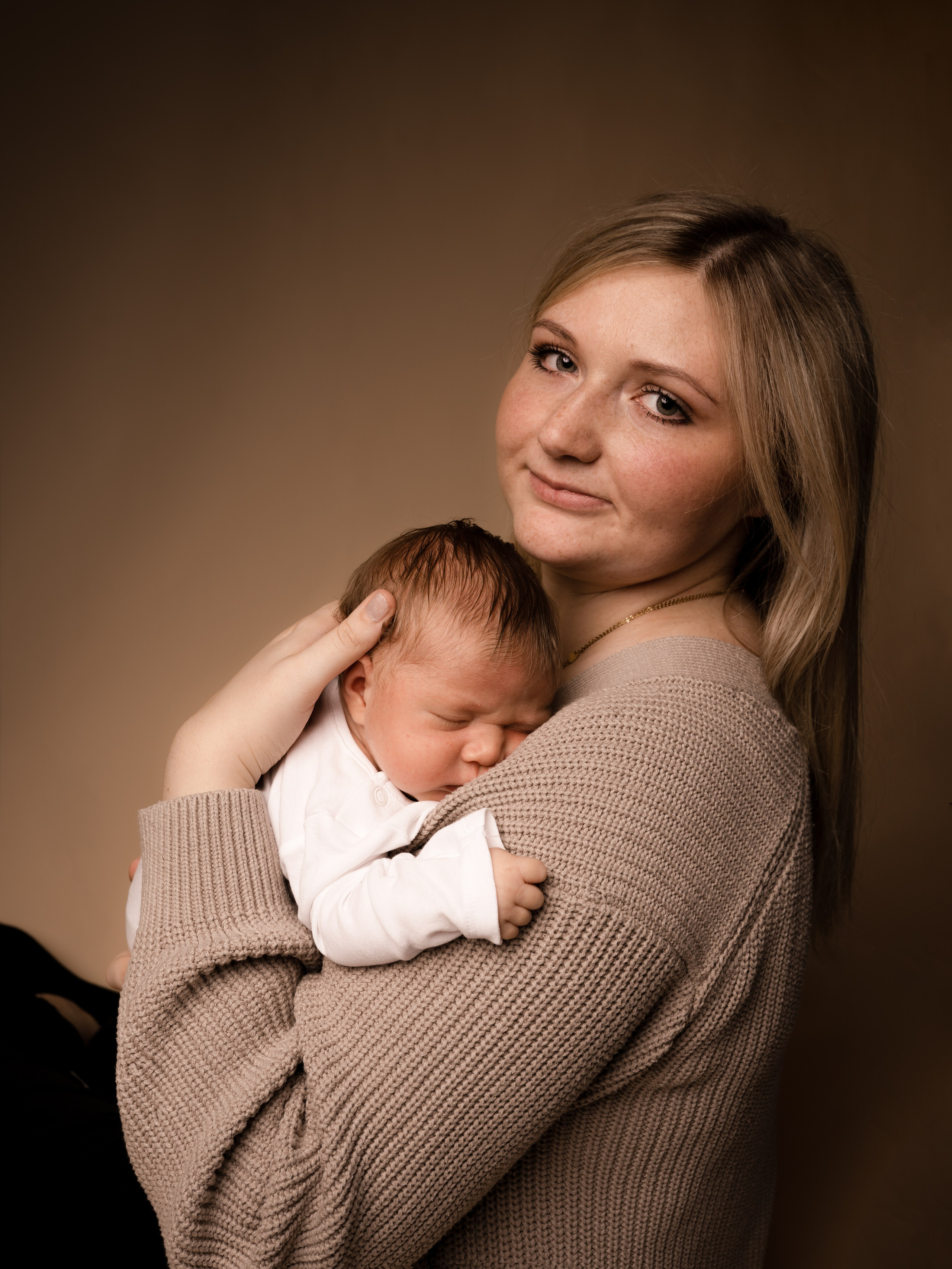 Mutter mit Baby im Arm, beide in einem friedlichen Moment