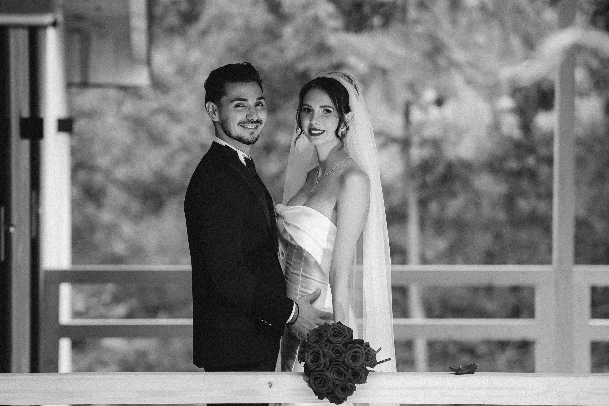 Portret creativ cu mirii în ferestrele mari ale locației Cabana Masiv.