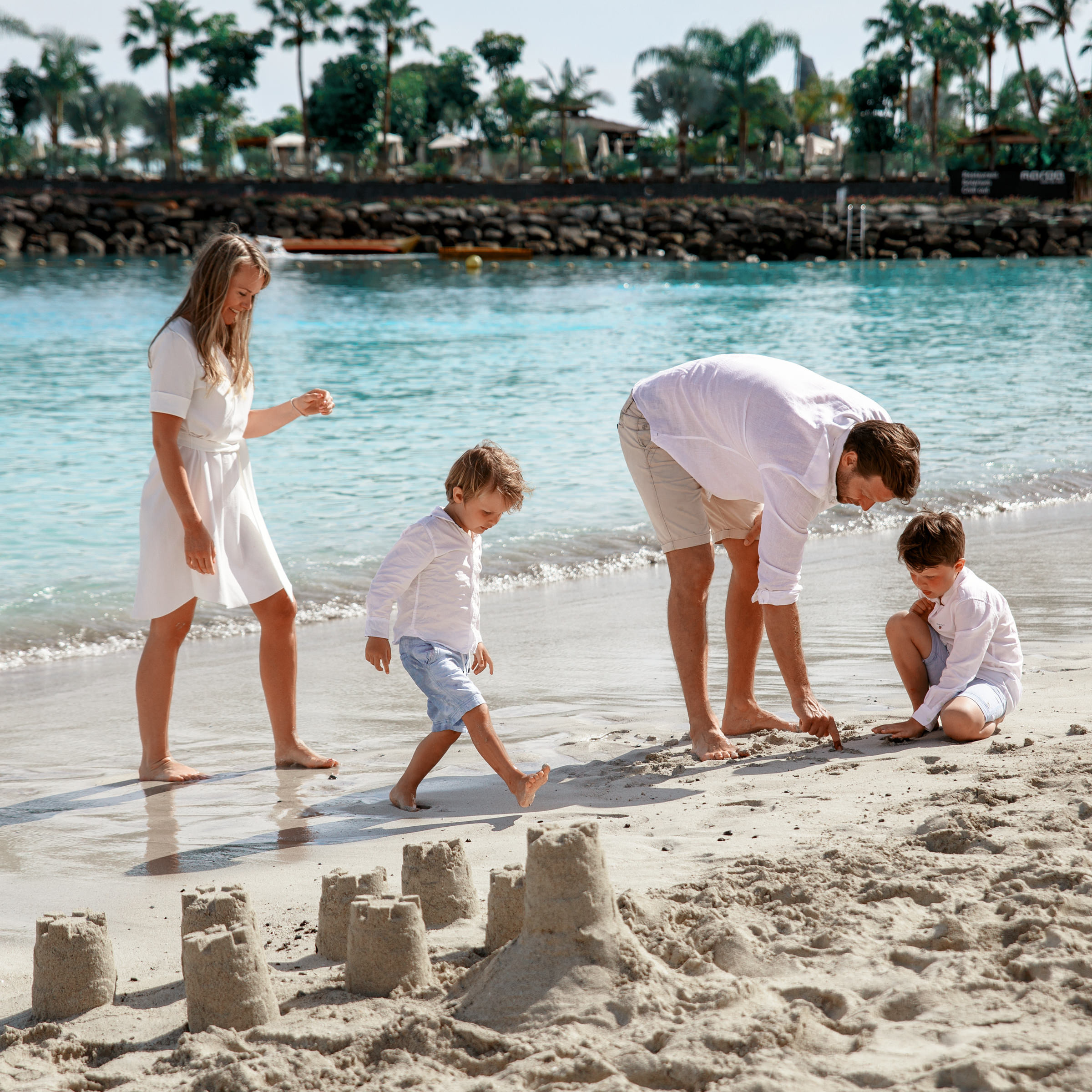 A family playing in the sand on the beach Photographer