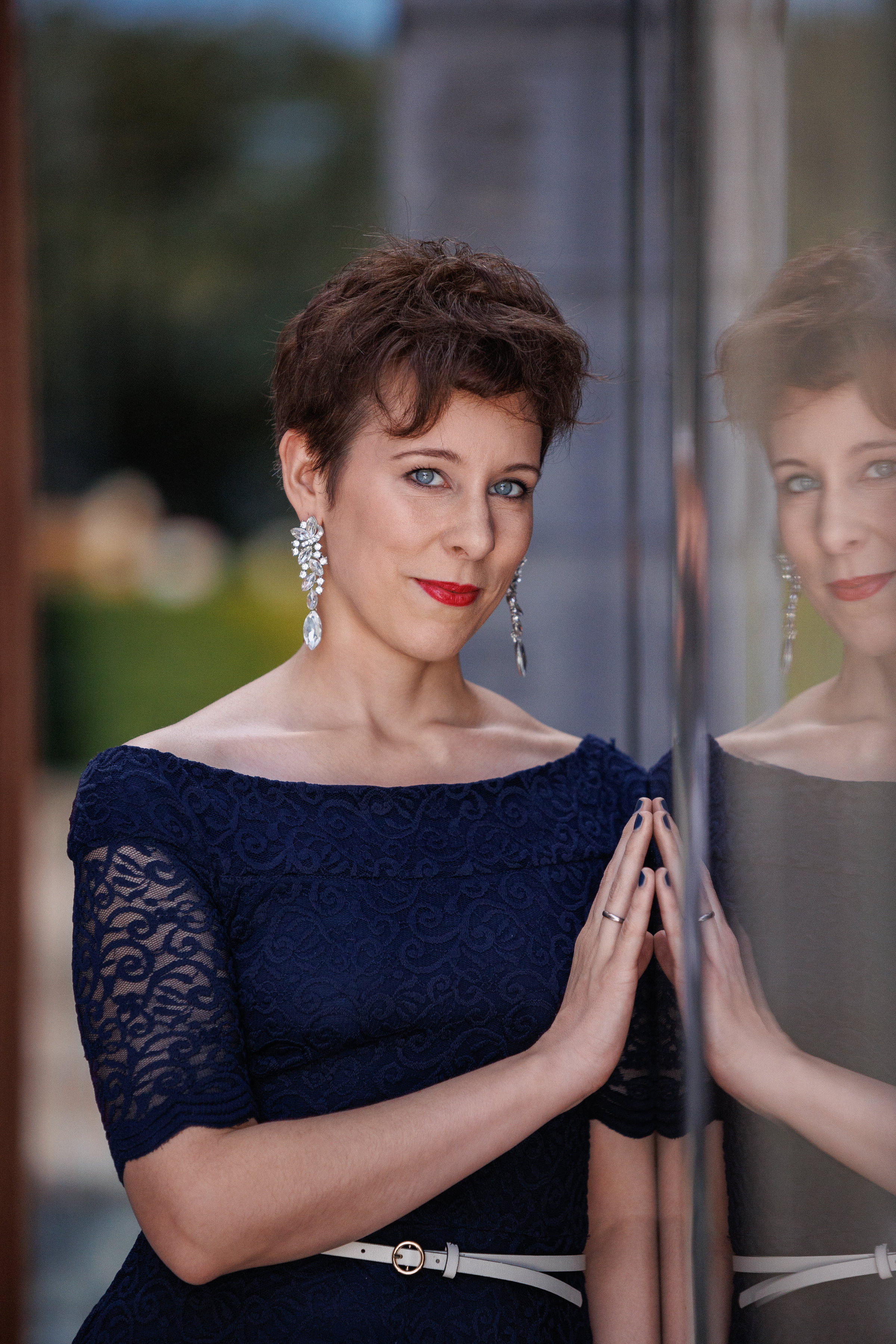 A woman in a blue dress posing in front of a mirror.