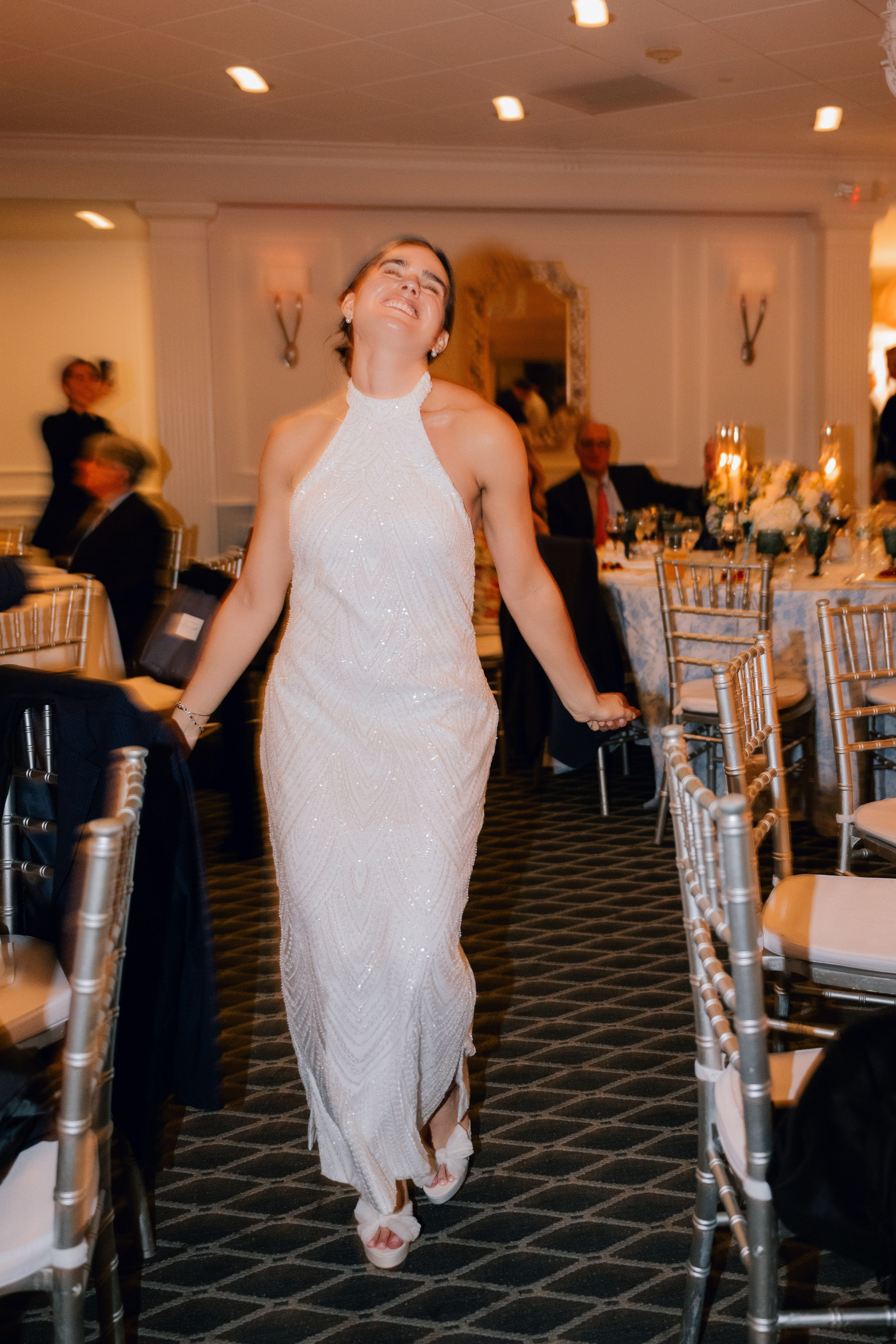 a woman in a white dress is walking down the aisle