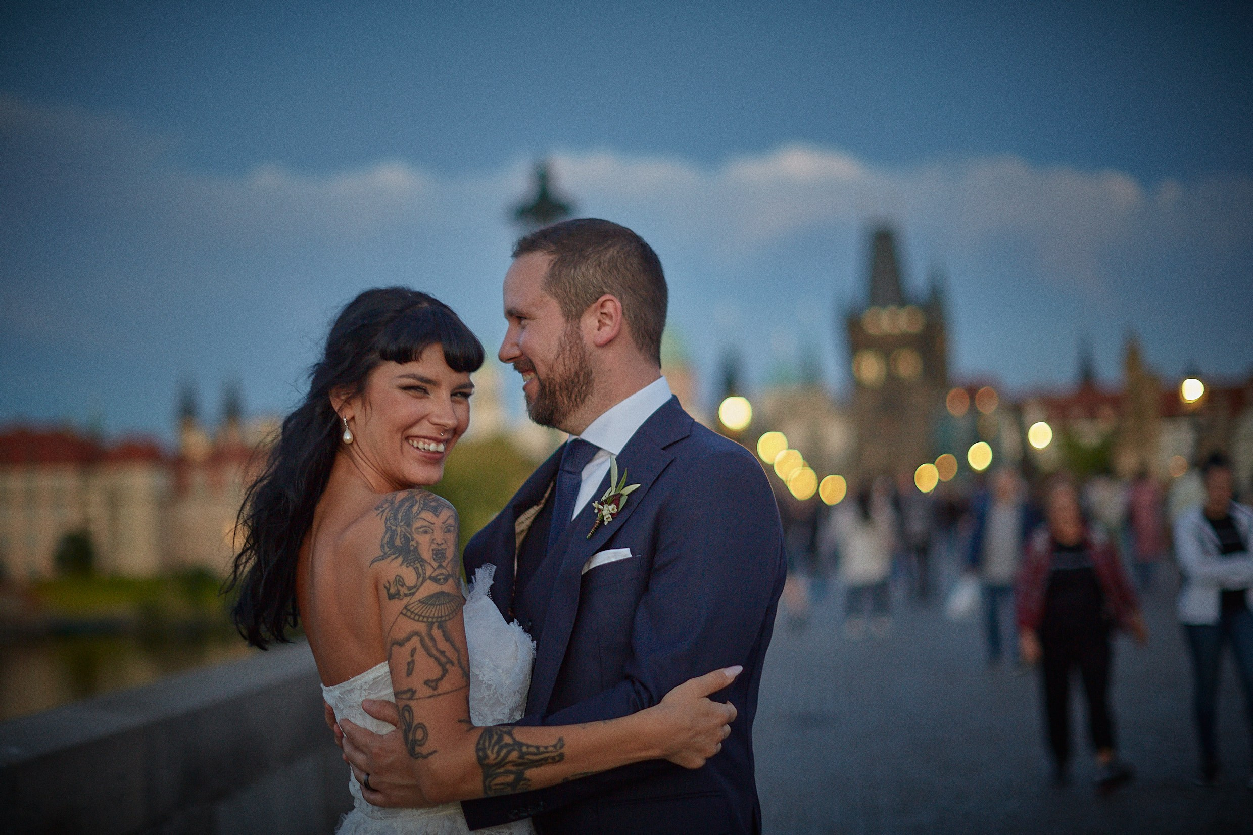Laughing couple under gas lamps on Charles Bridge.
