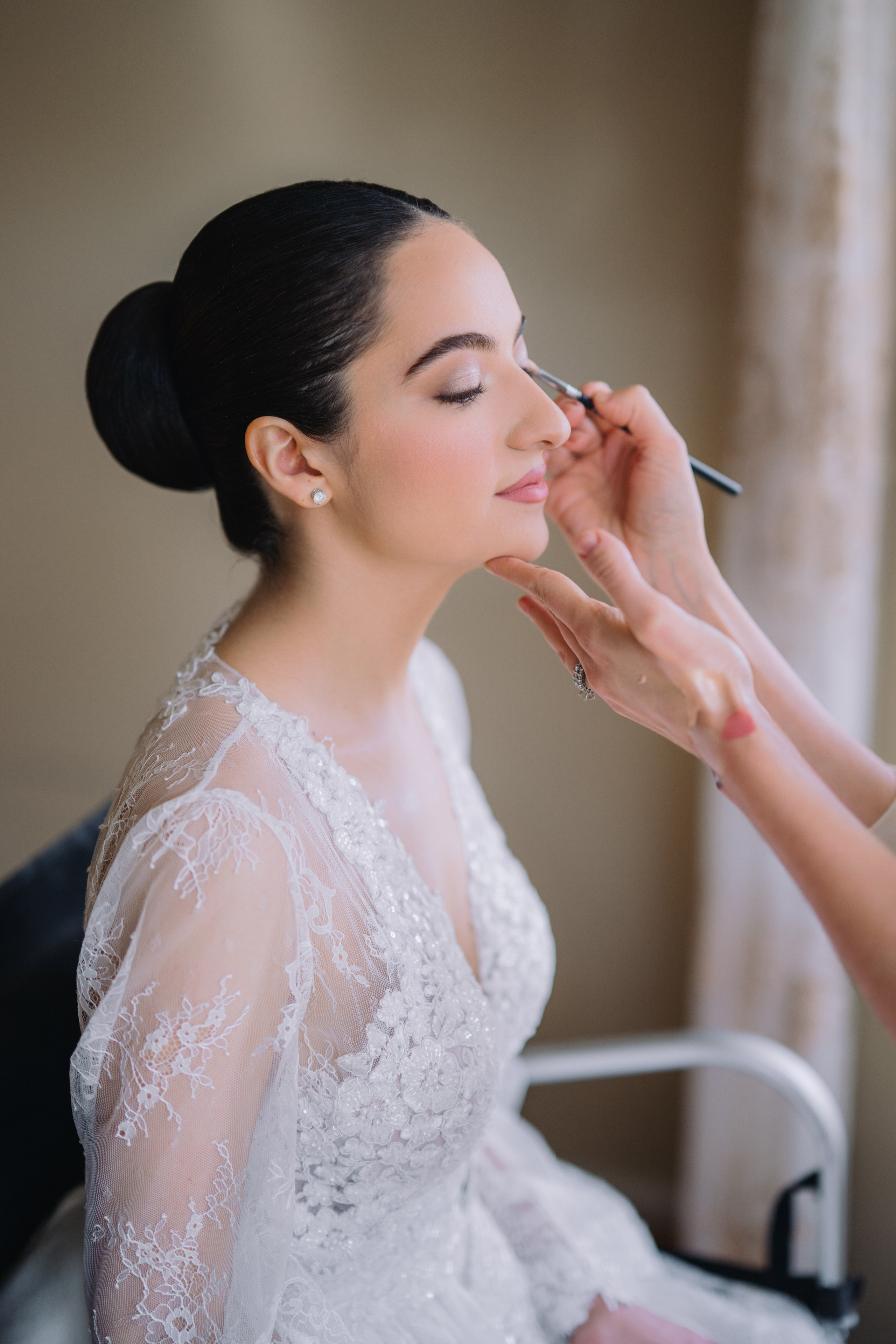 a woman is putting her makeup in the mirror
