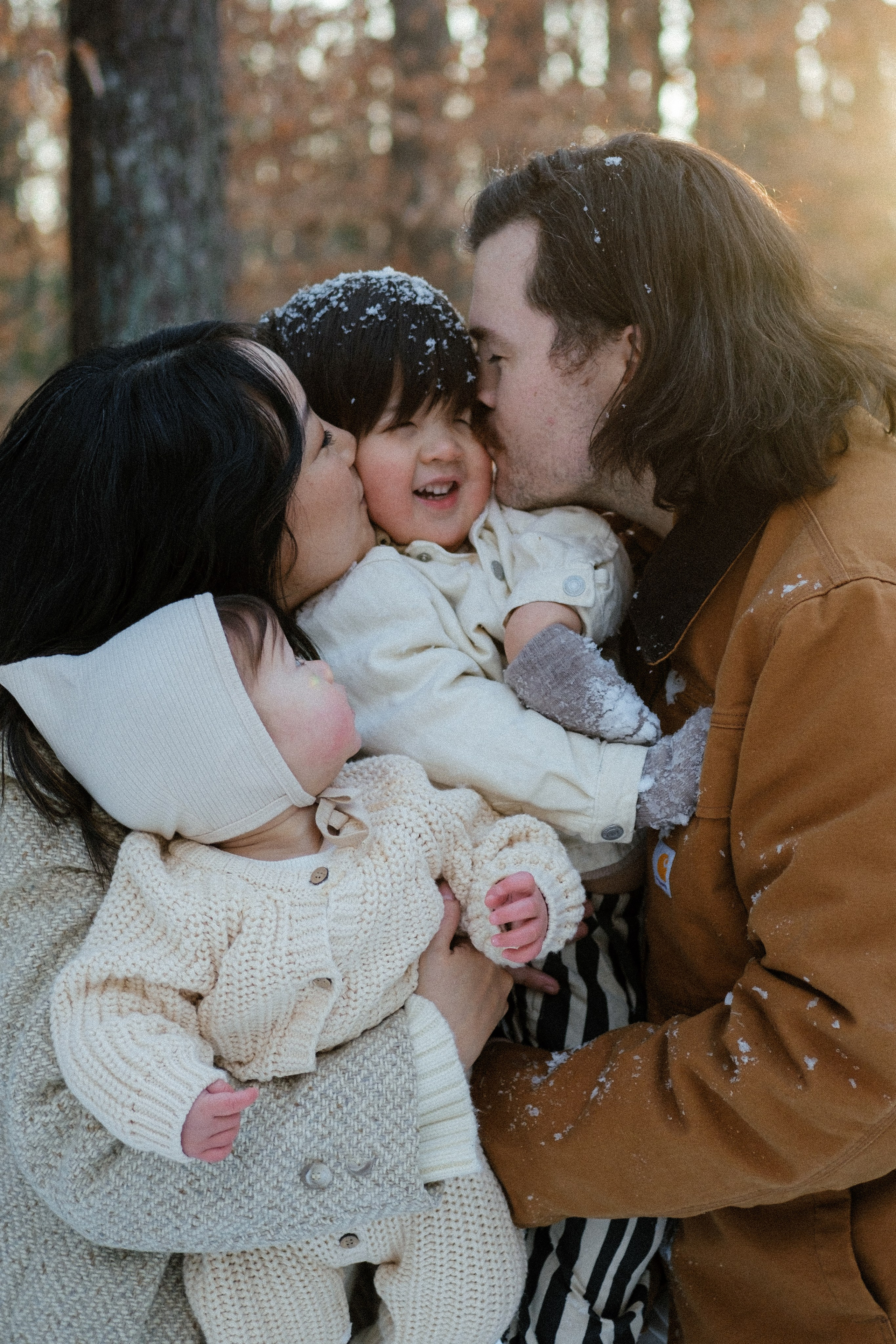 Family group hug in a snow-covered yard near Richmond, VA — love, laughter, and warmth in the winter forest.