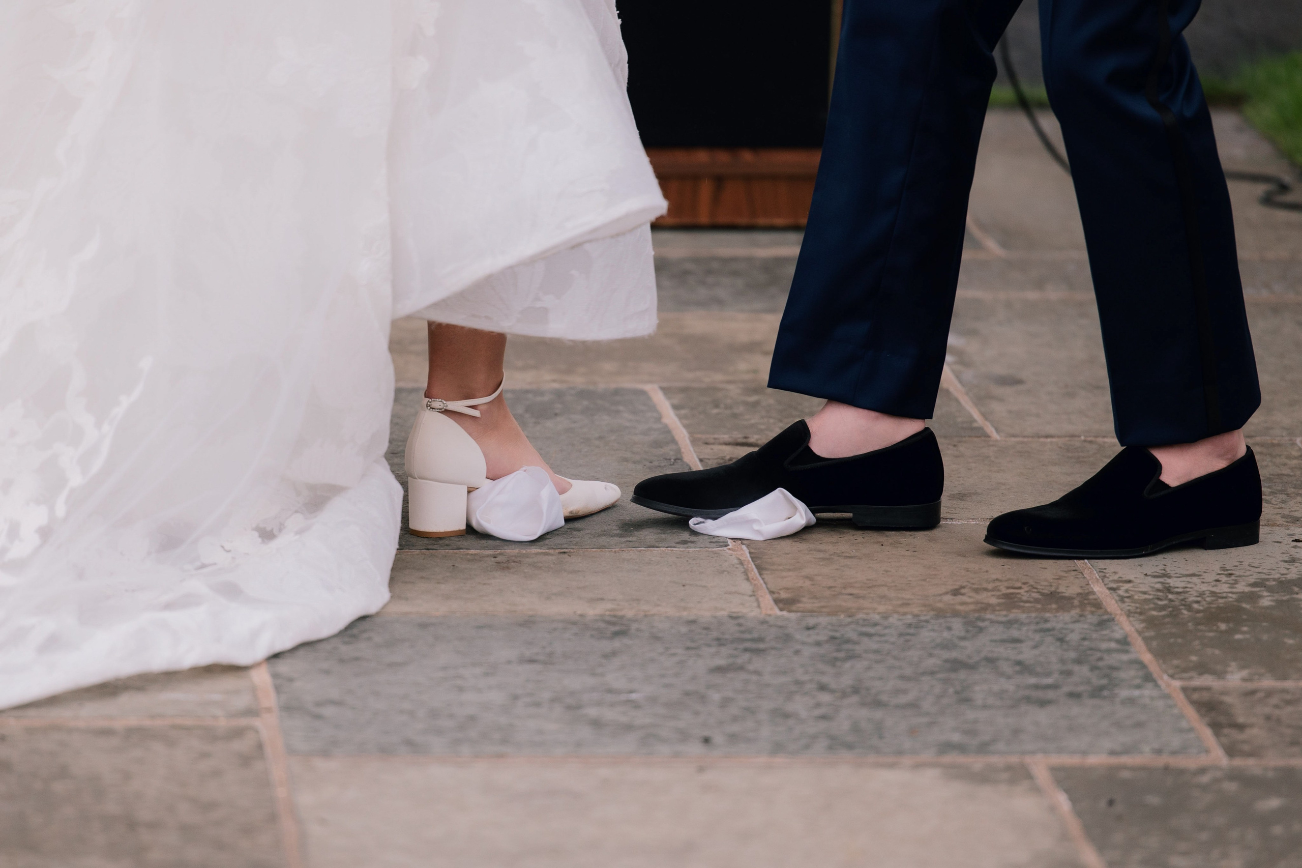 a bride and groom are standing on the sidewalk