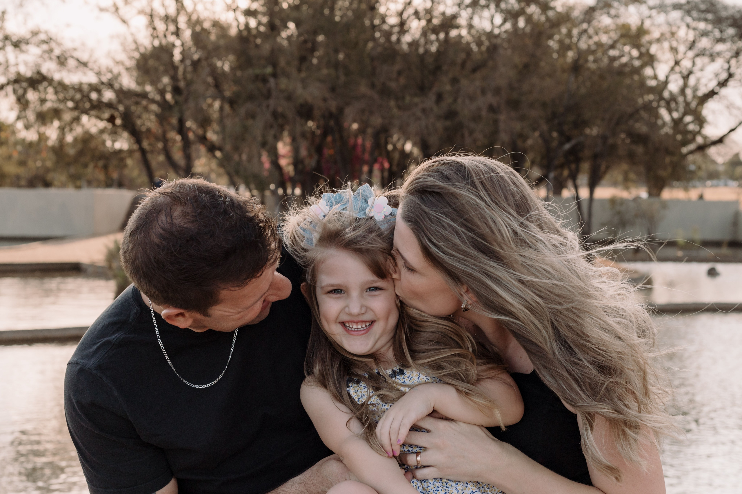 Pais brincando com a filha na Praça dos Cristais