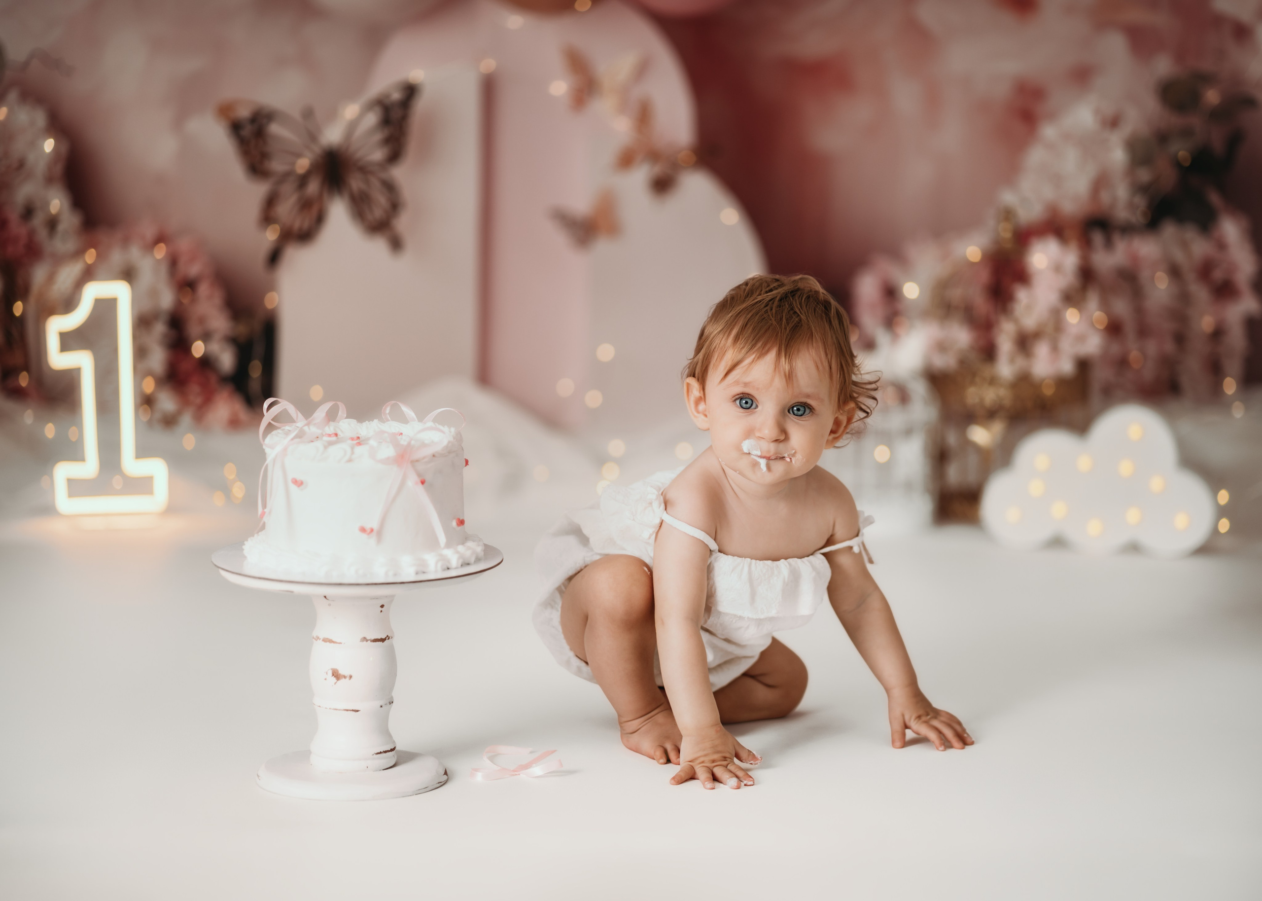 Cake smash Beograd – devojčica pored torte u dekoraciji leptira i balona