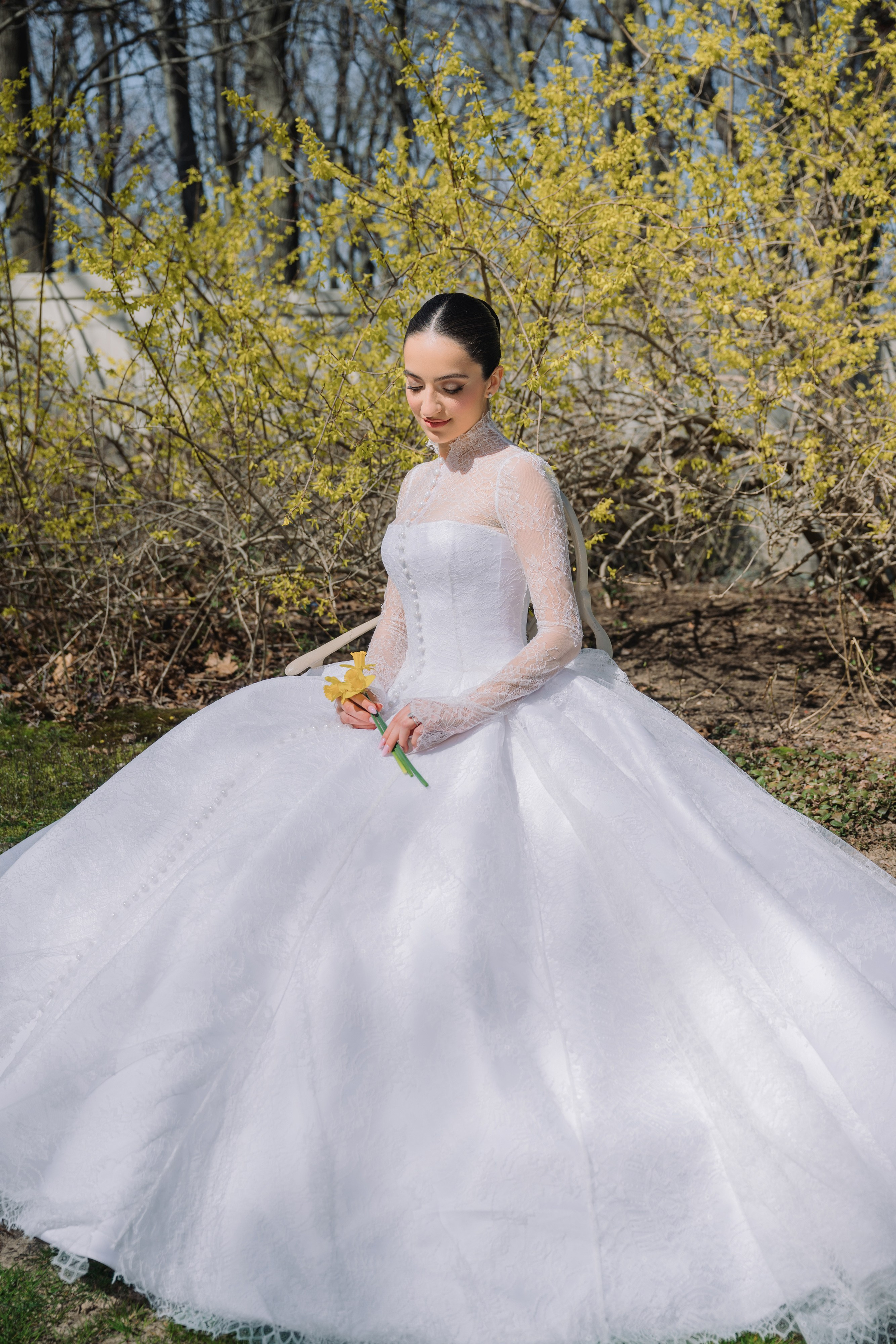 a woman in a white wedding dress sitting on the grass