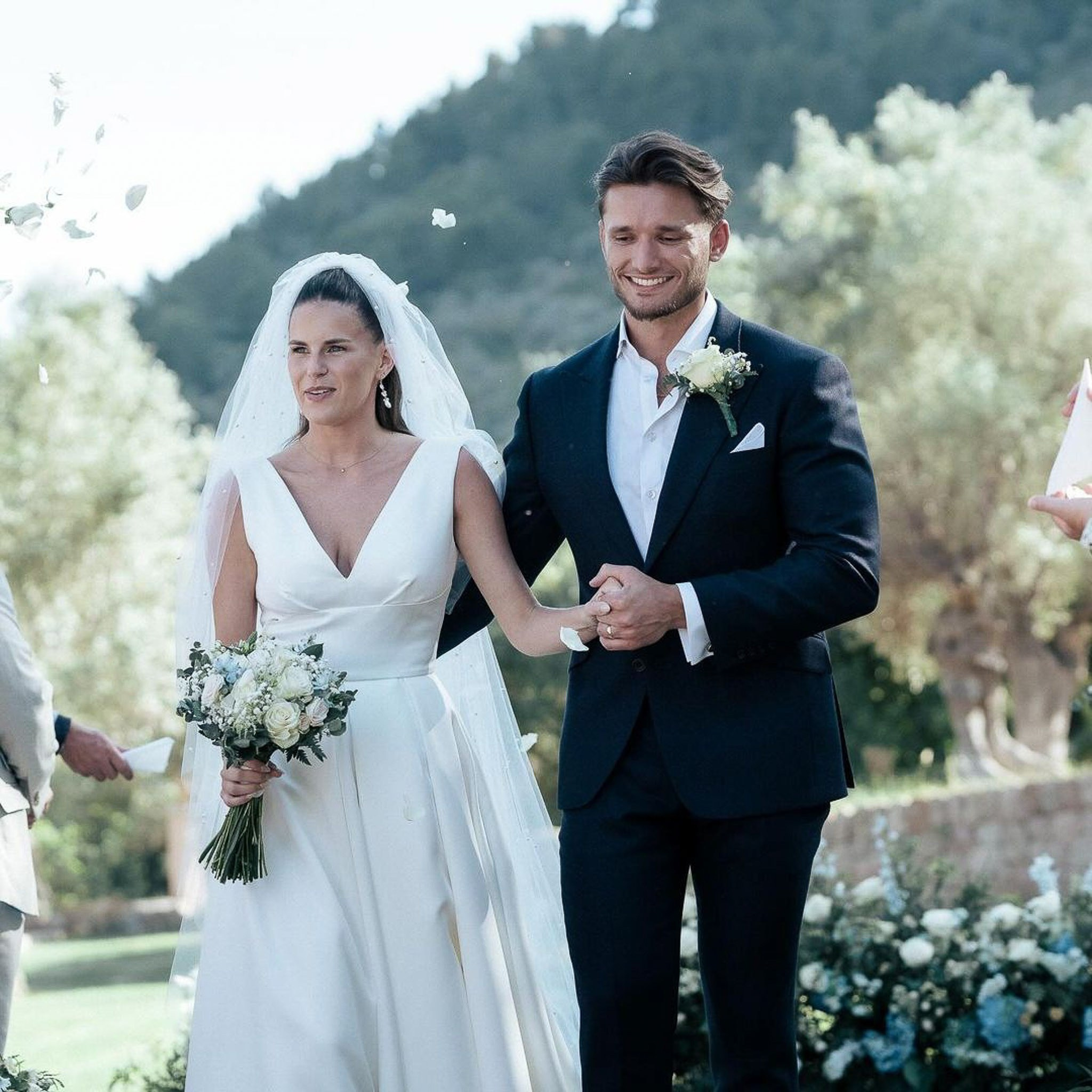 Bride and groom walking back down the aisle as guests throw petals at their Mallorca wedding