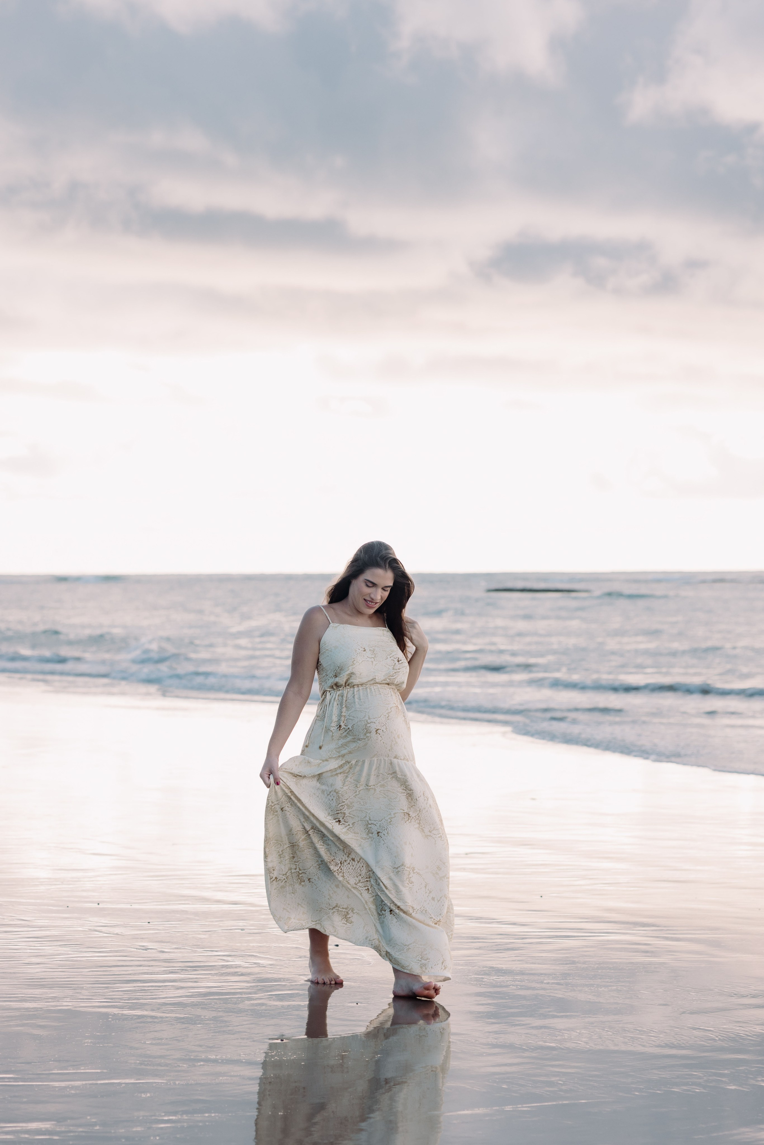 Gestante caminhando sozinha na Praia do Paiva