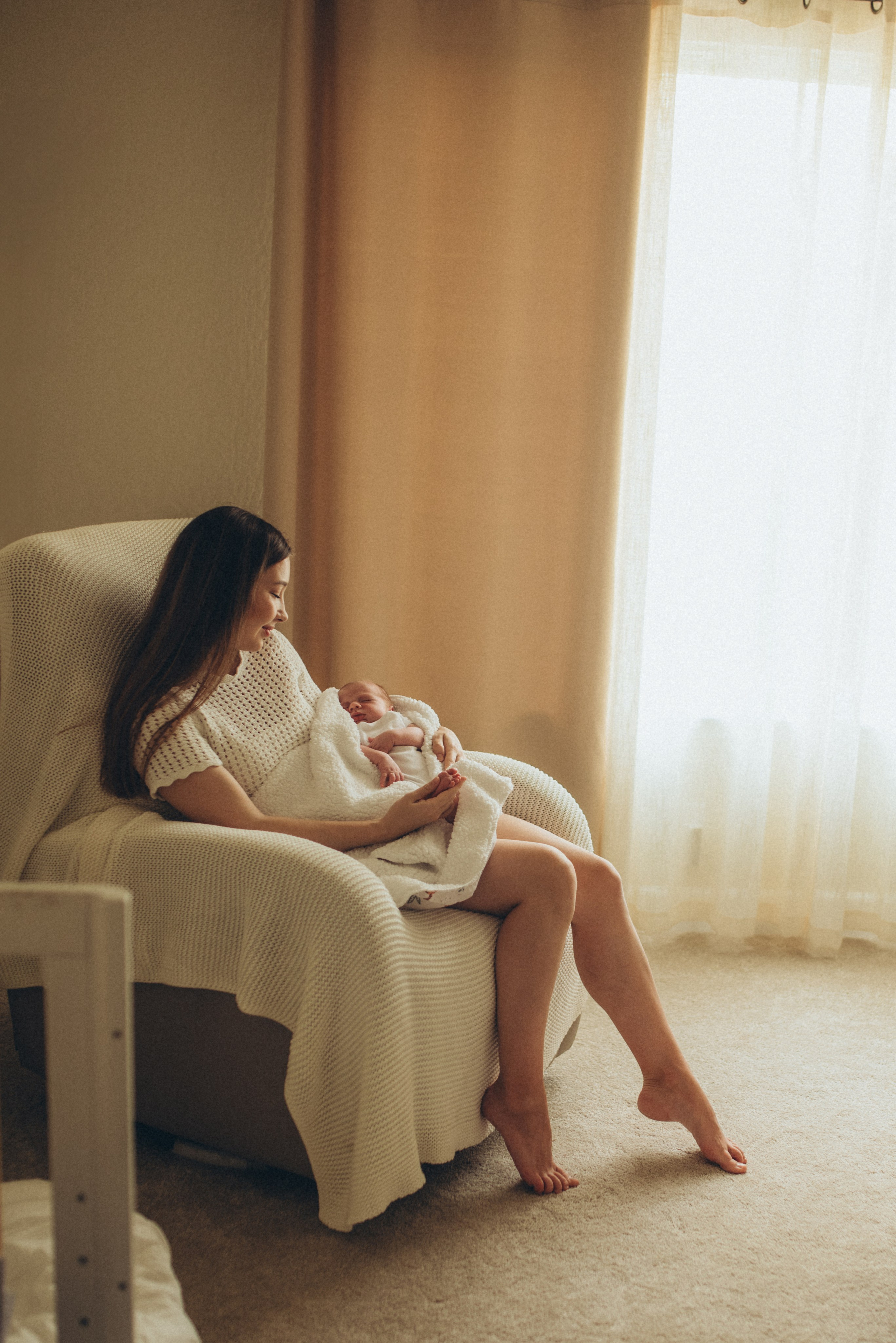 mom is sitting with a newborn baby