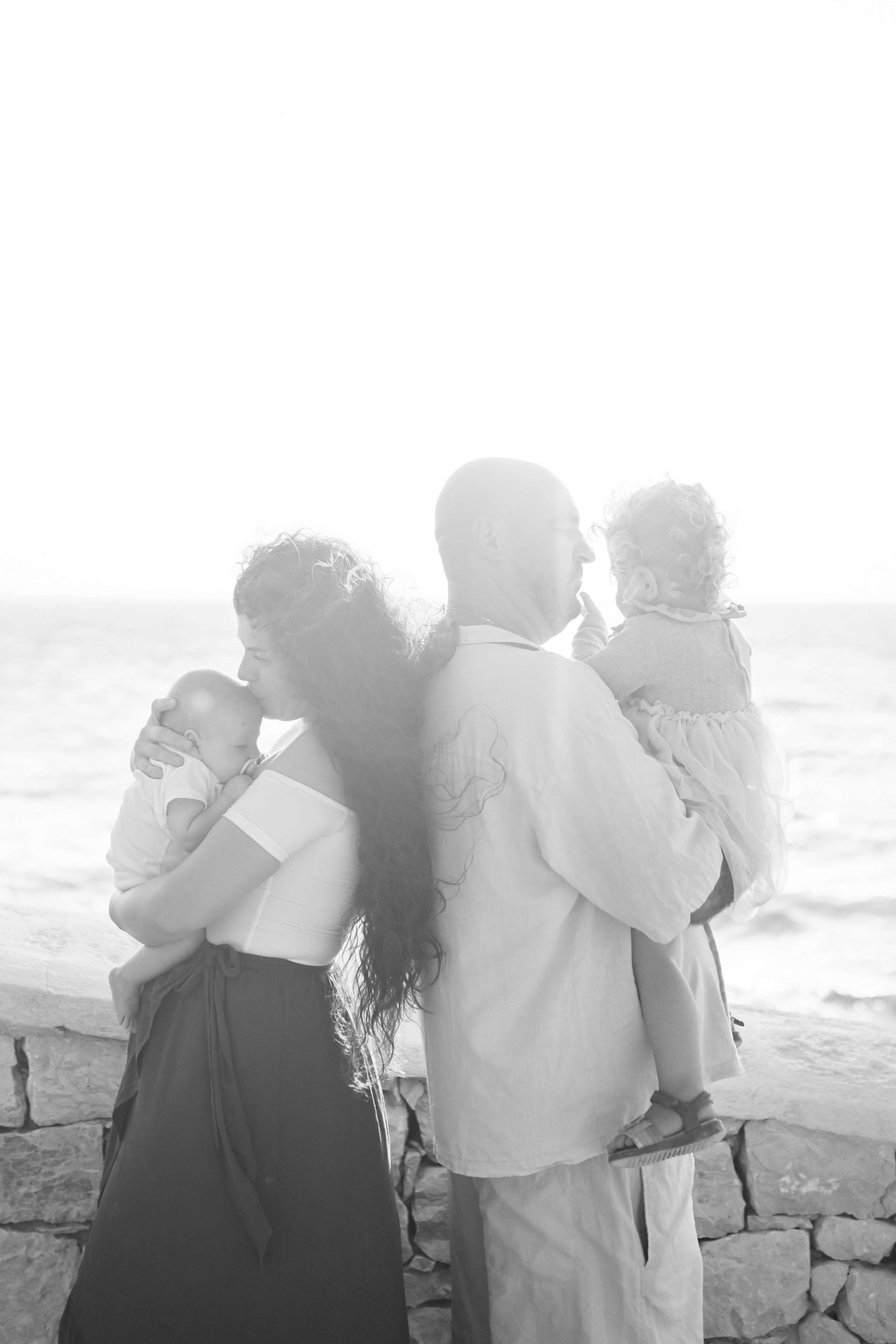 Happy family walking along a Rhodes beach at sunset. Photographer in Rhodes Island