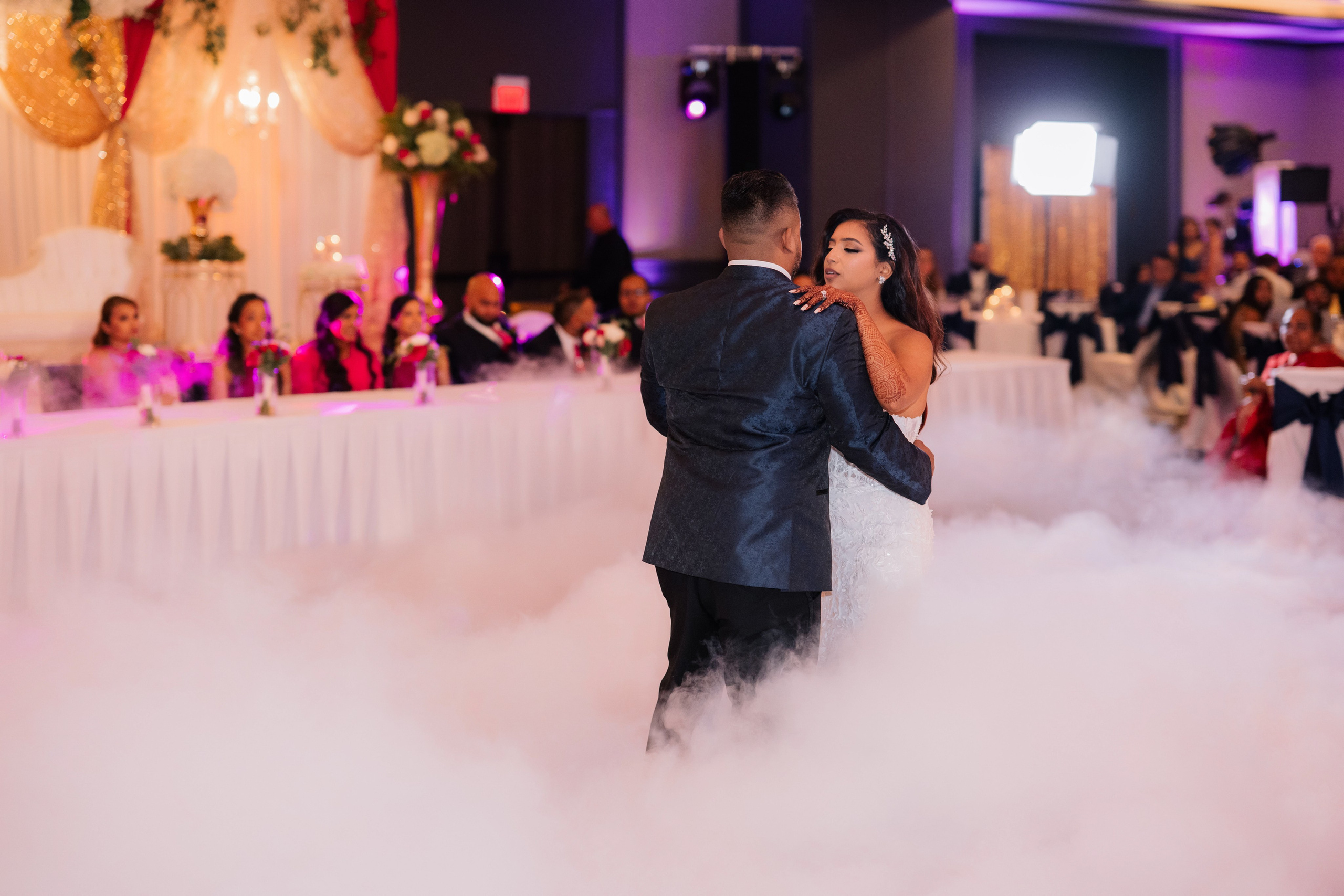 a bride and groom dance in the clouds at their wedding reception