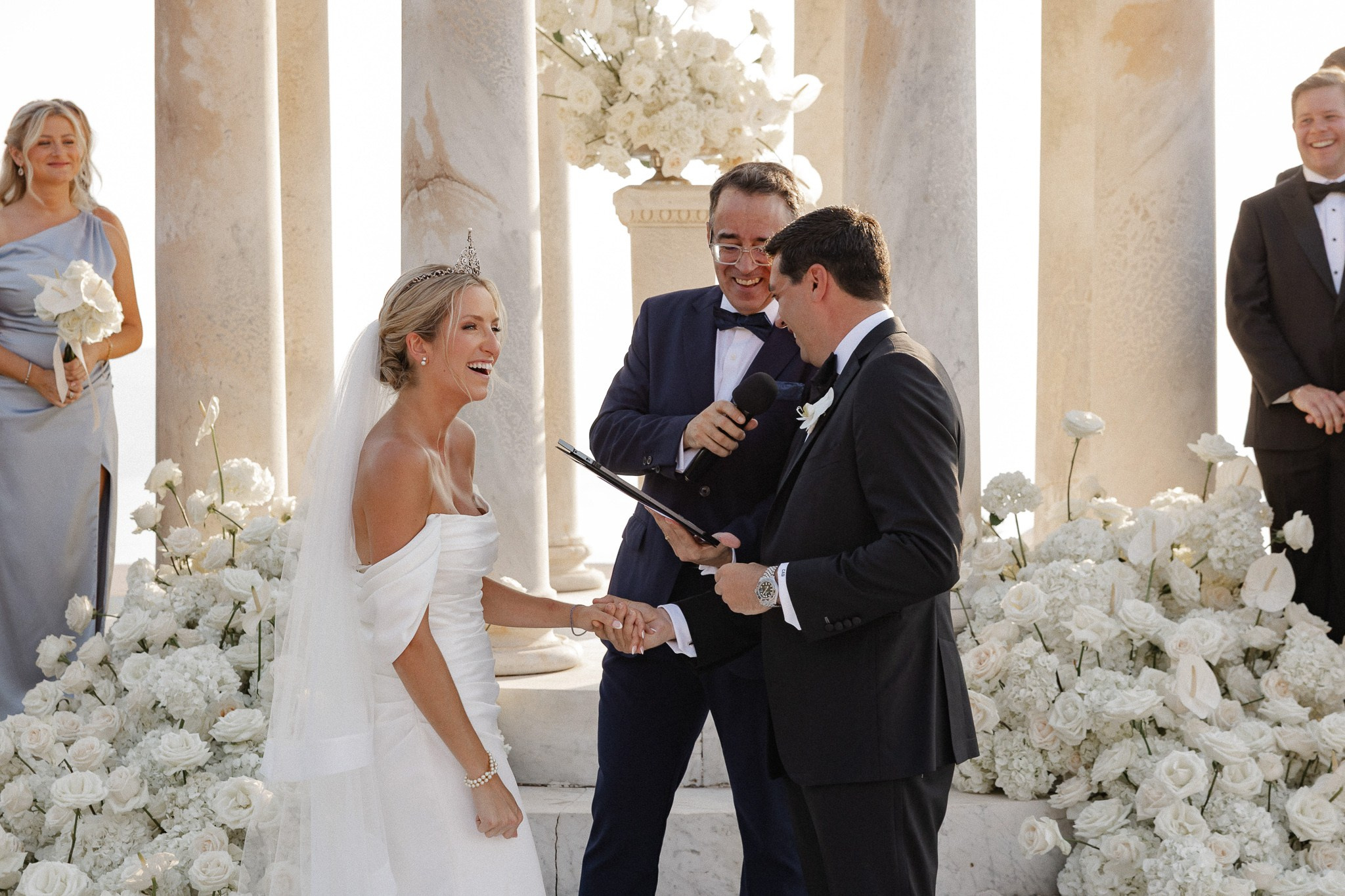 Bride and groom laughing together as their officiant reads the ceremony at Son Marroig