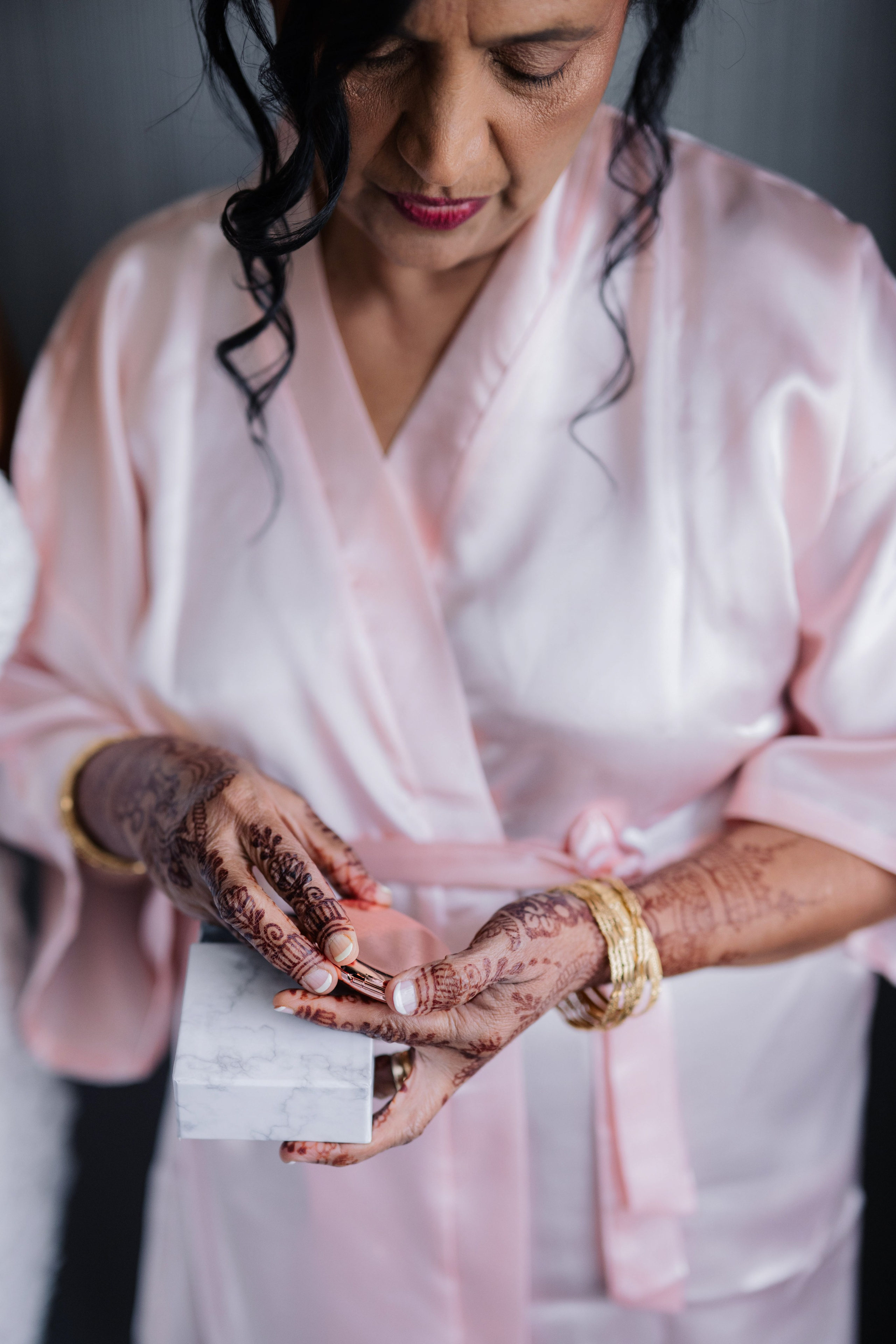a woman in a pink robe holding a white card