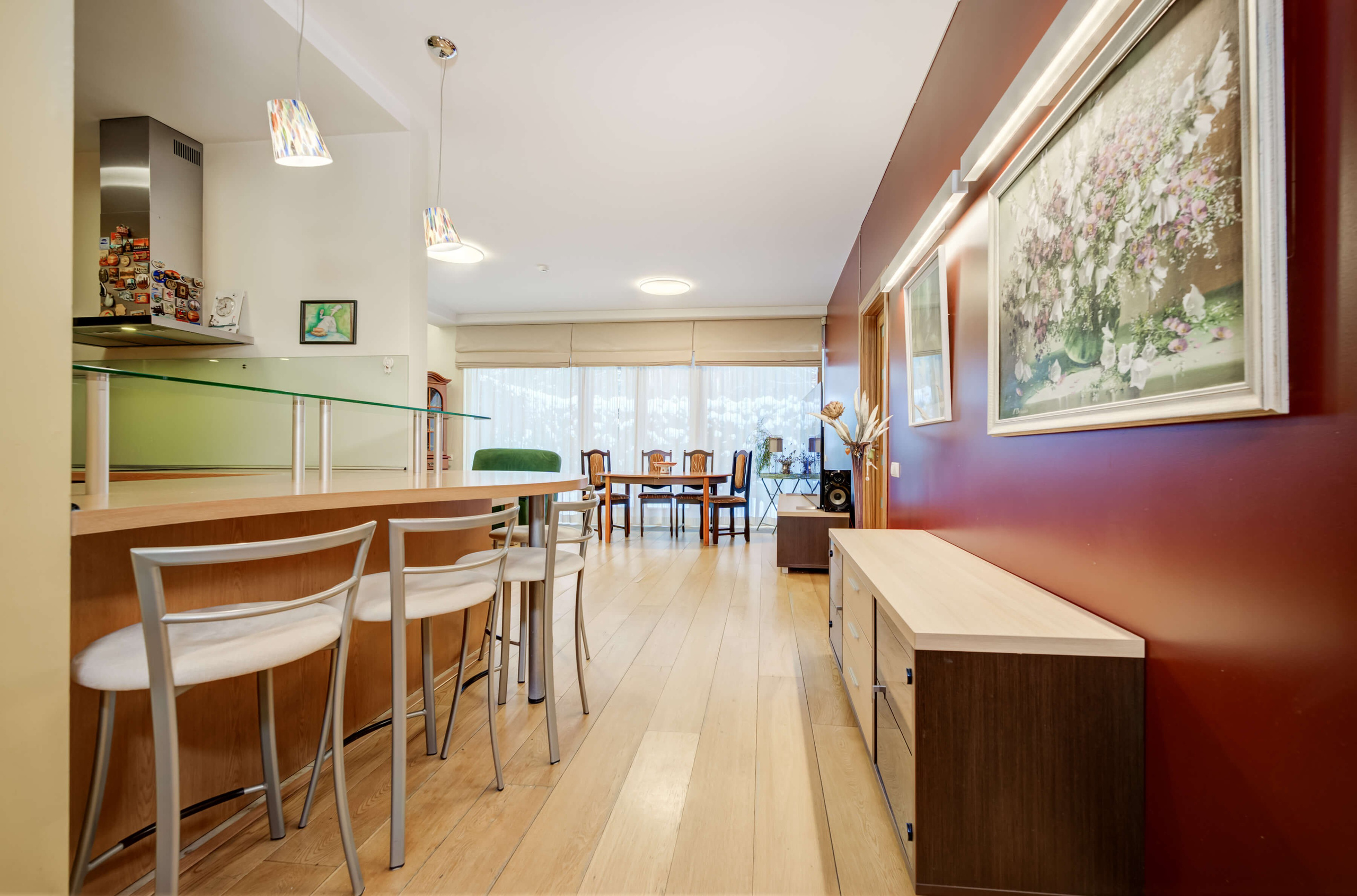 Erdvi svetainė su dizainerio paveikslais ir išėjimu į plačią terasą 4 kambarių bute Vilniuje