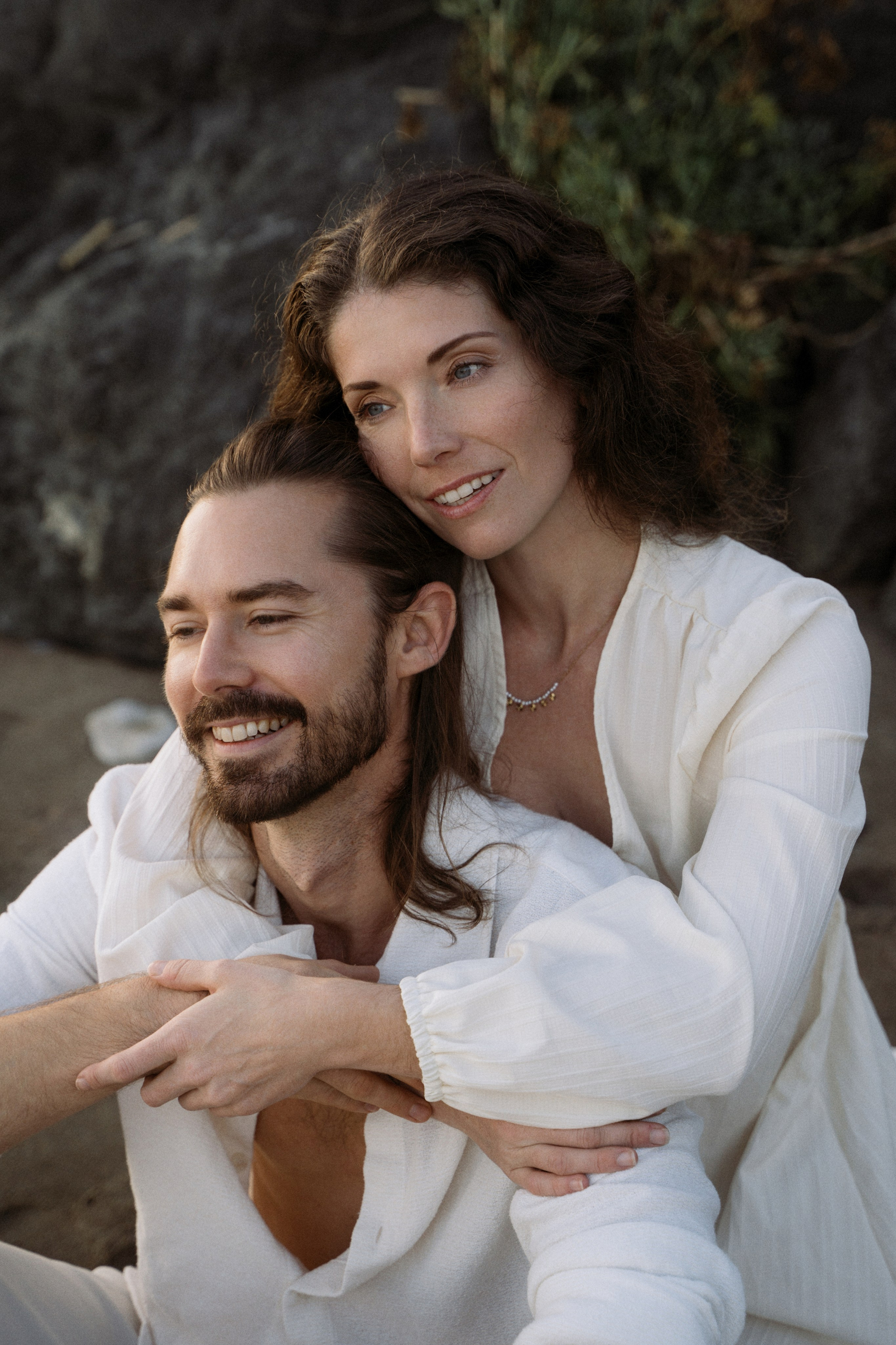 Seaside romance. Beautiful woman hugging her husband