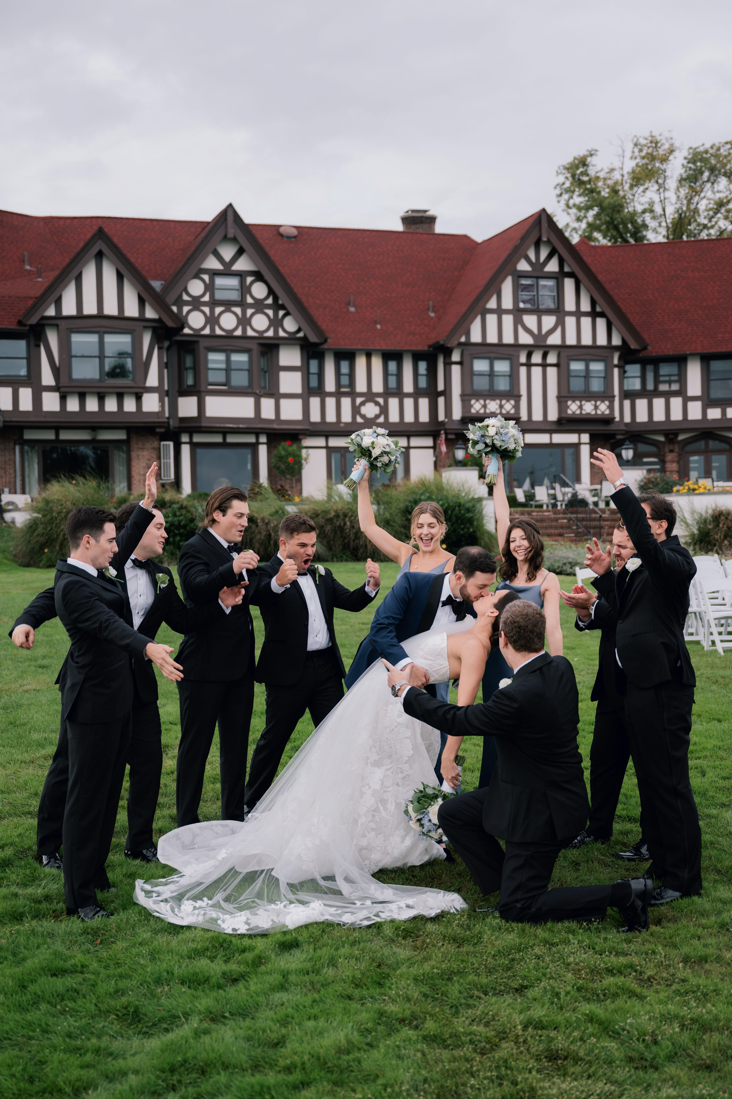 a group of people standing around a bride and groom