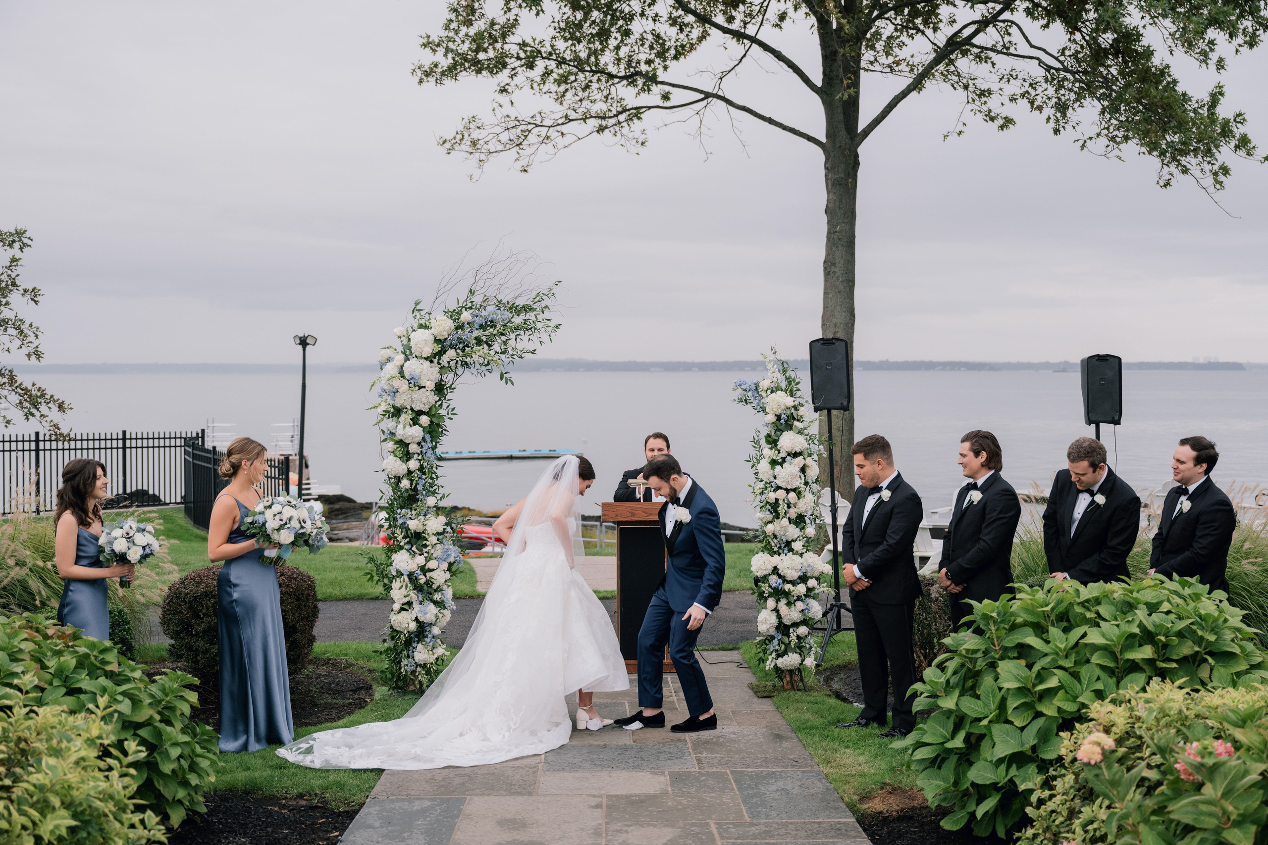 a bride and groom are standing in front of a tree