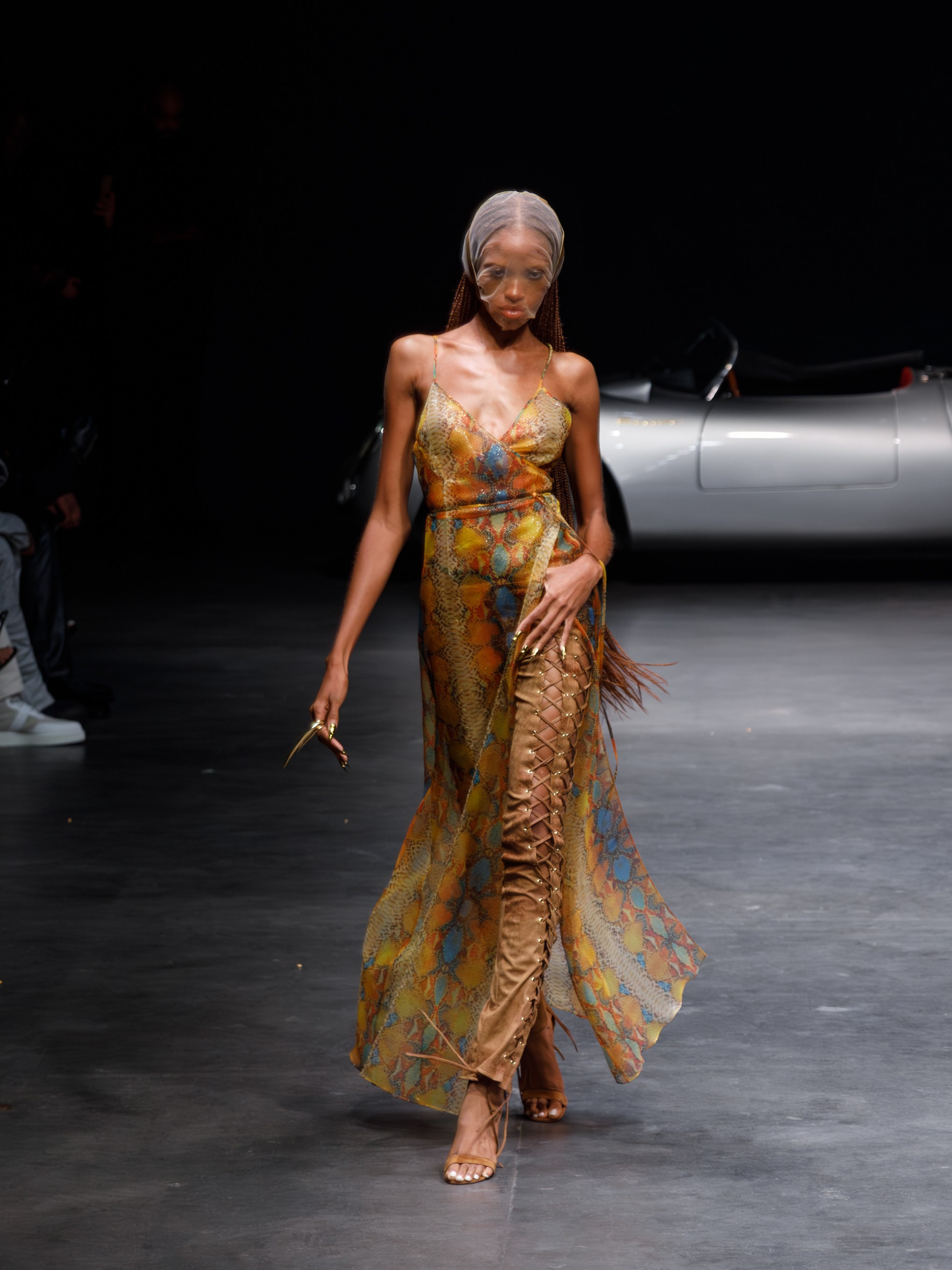 Runway model in dramatic gold dress swirl – couture runway shot
