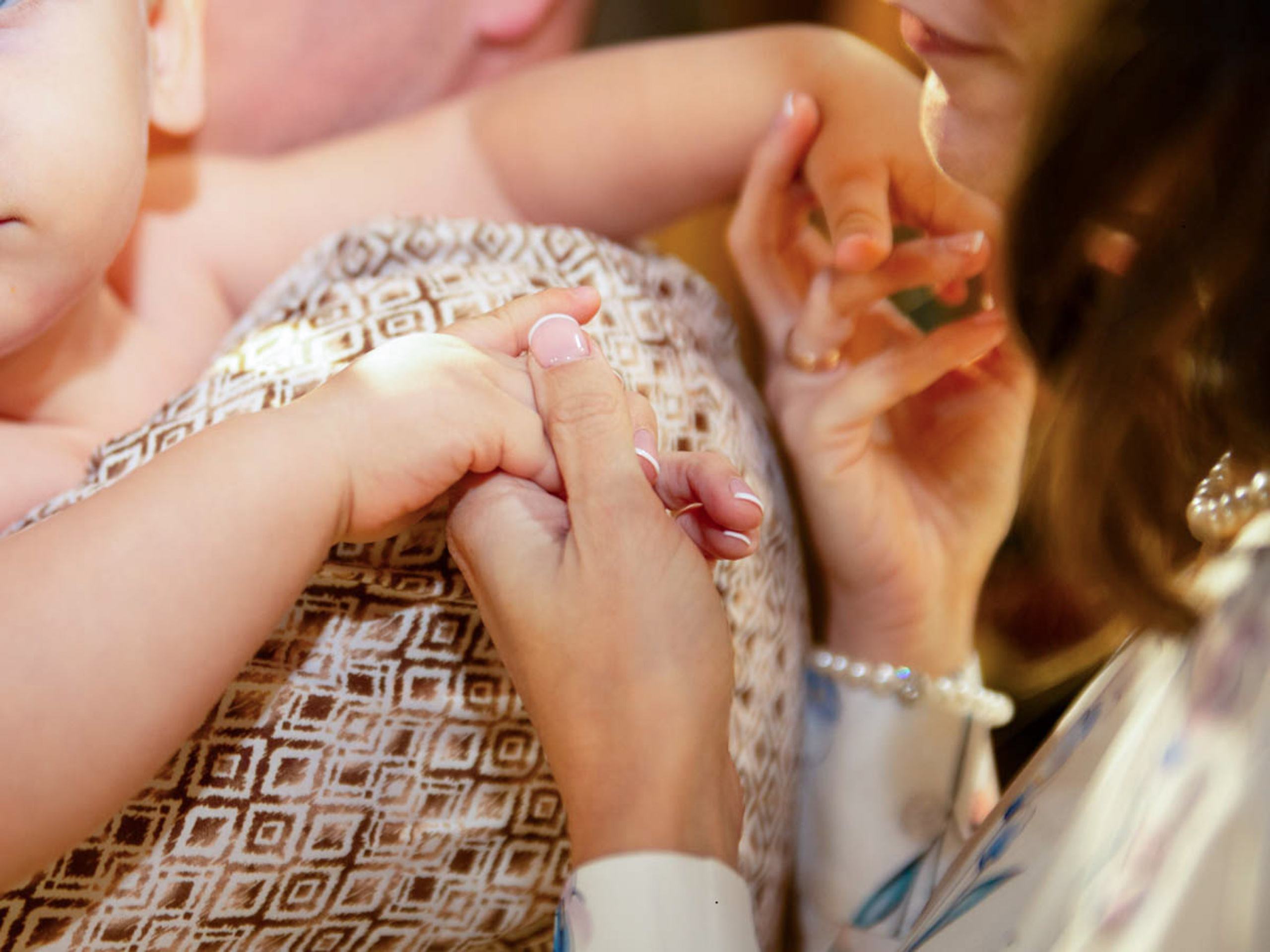Godparents holding the child during the baptism ceremony