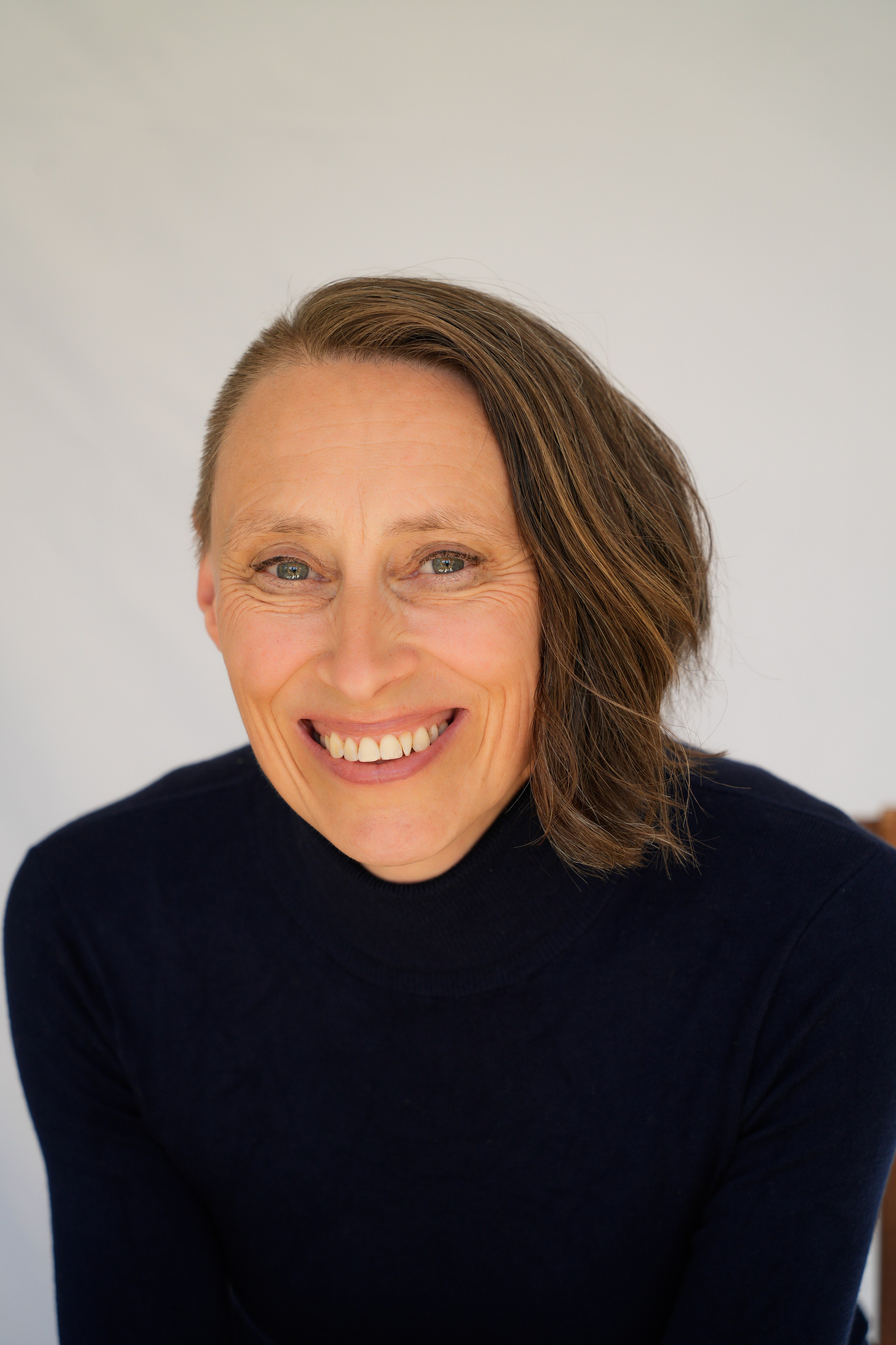 Bright, smiling actor headshot with clean white background, ideal for commercial and advertising roles.