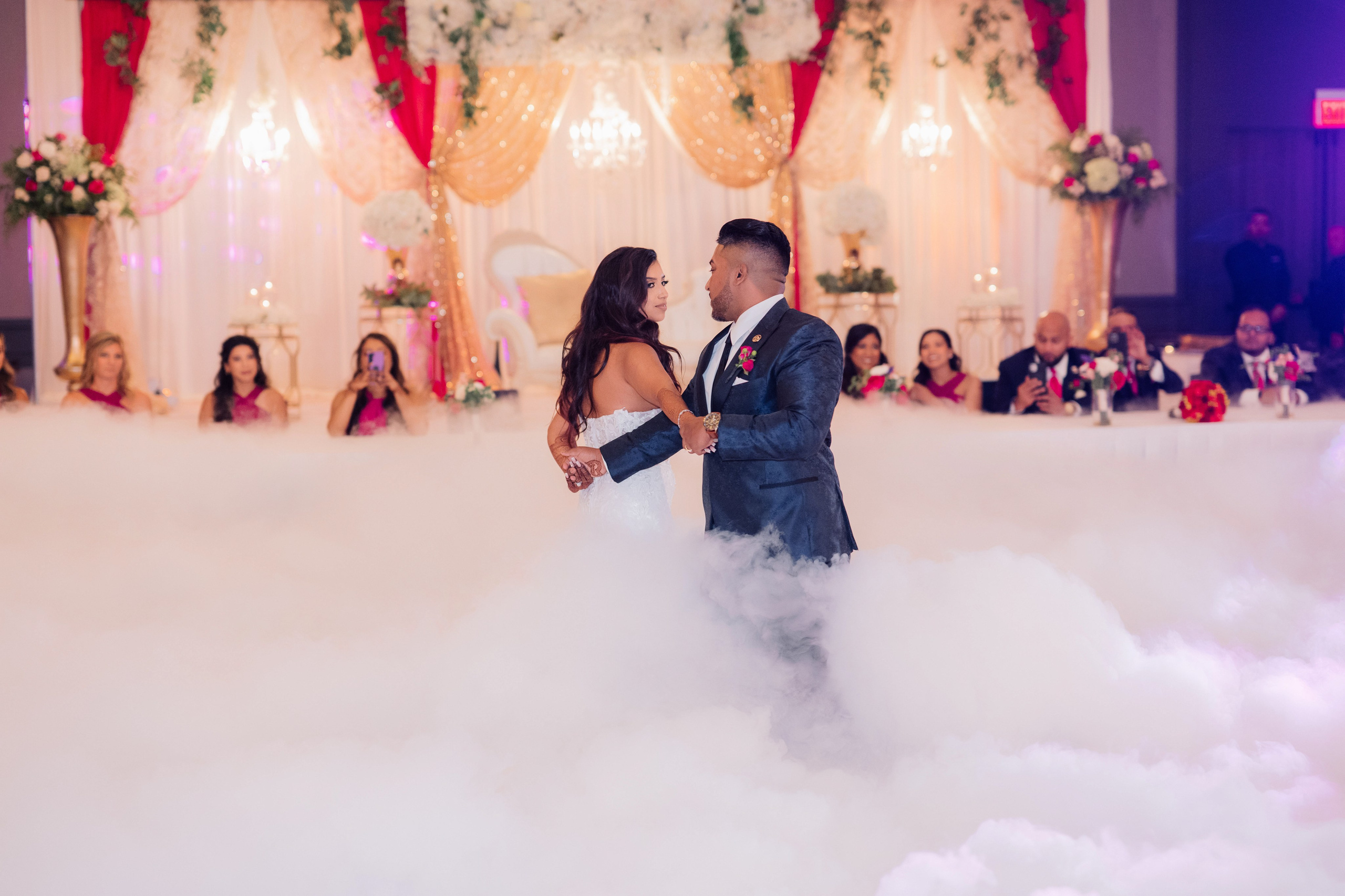 a bride and groom dancing in the clouds