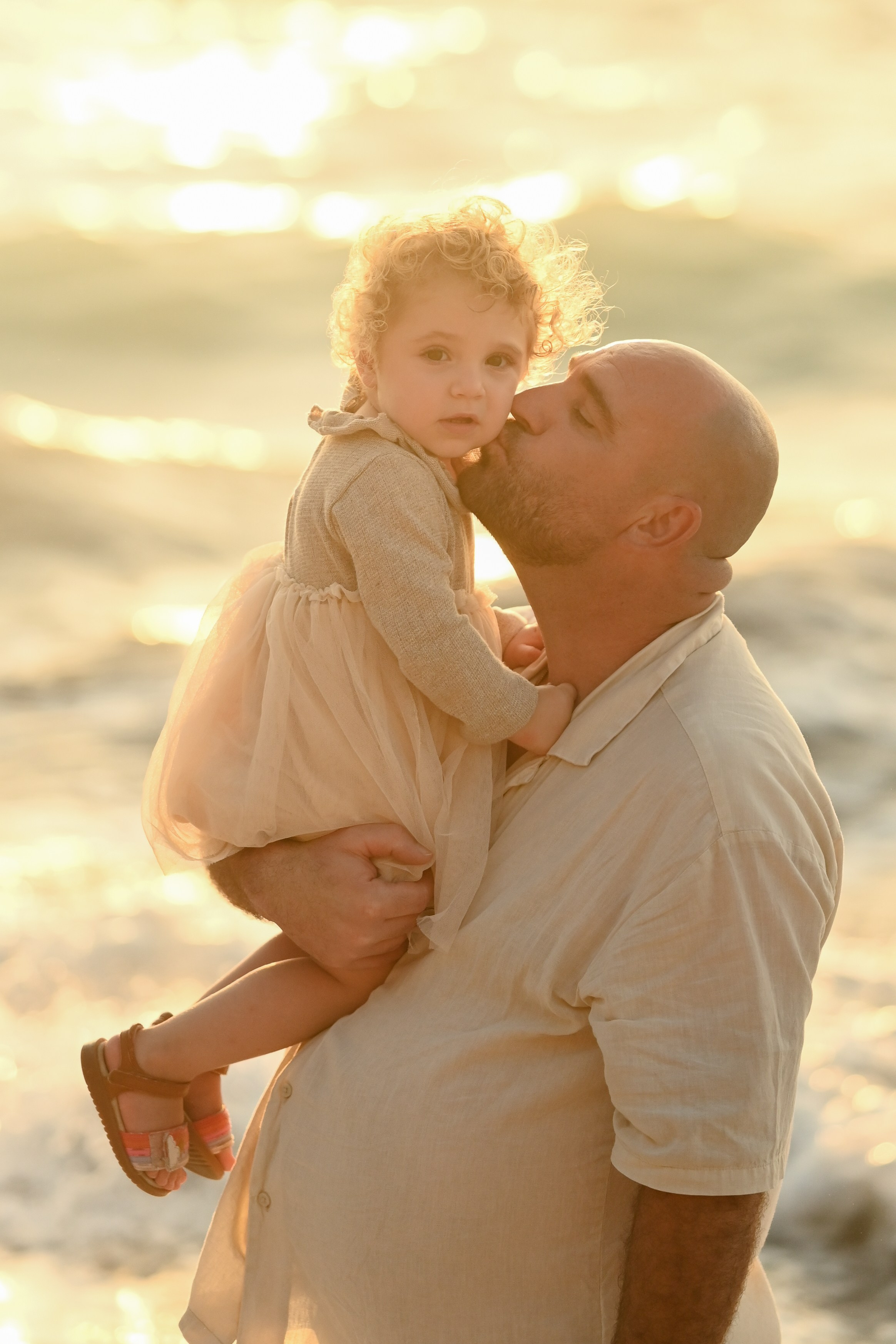 Happy family walking along a Rhodes beach at sunset. Photographer in Rhodes Island